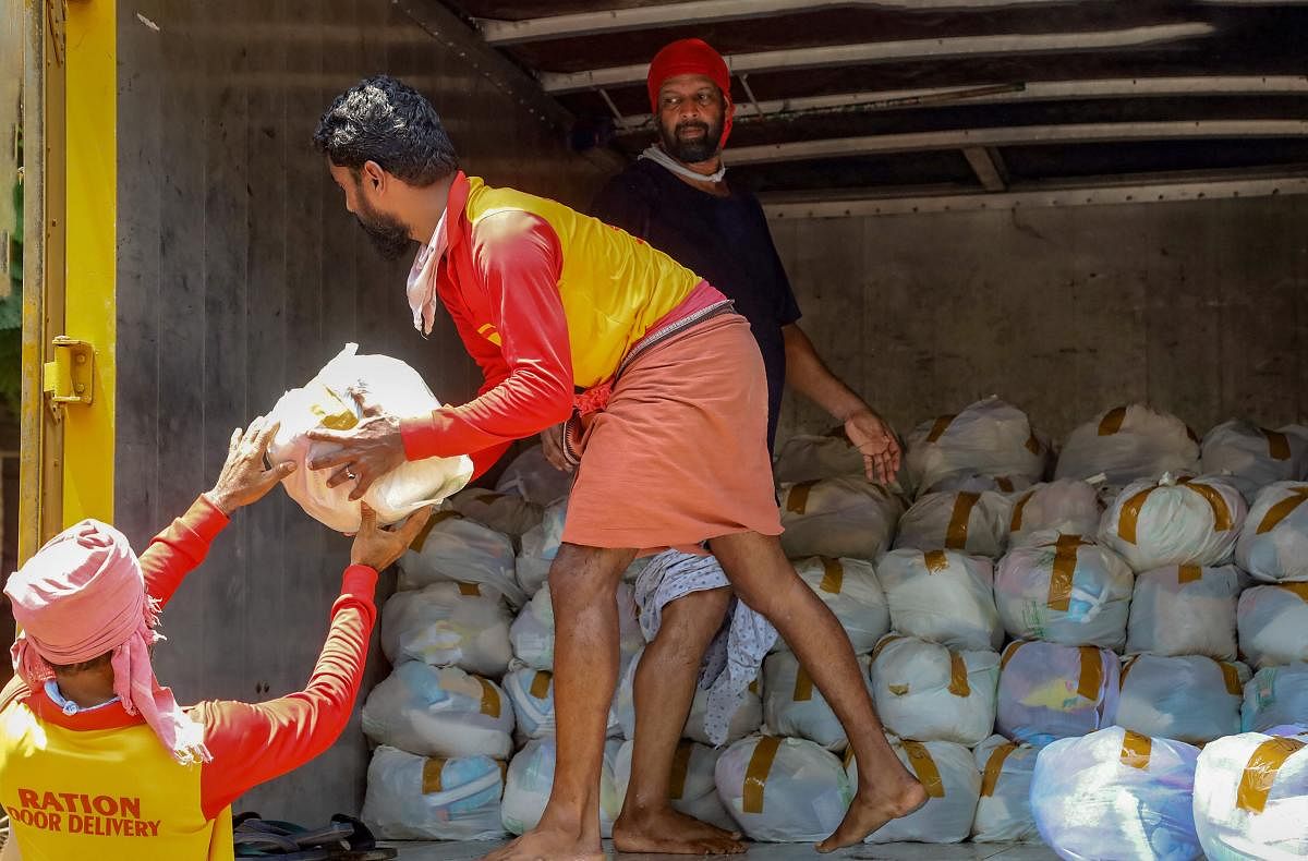 Workers load essential kits to be distributed among the needy for free during the nationwide lockdown to curb the spread of coronavirus (PTI Photo)