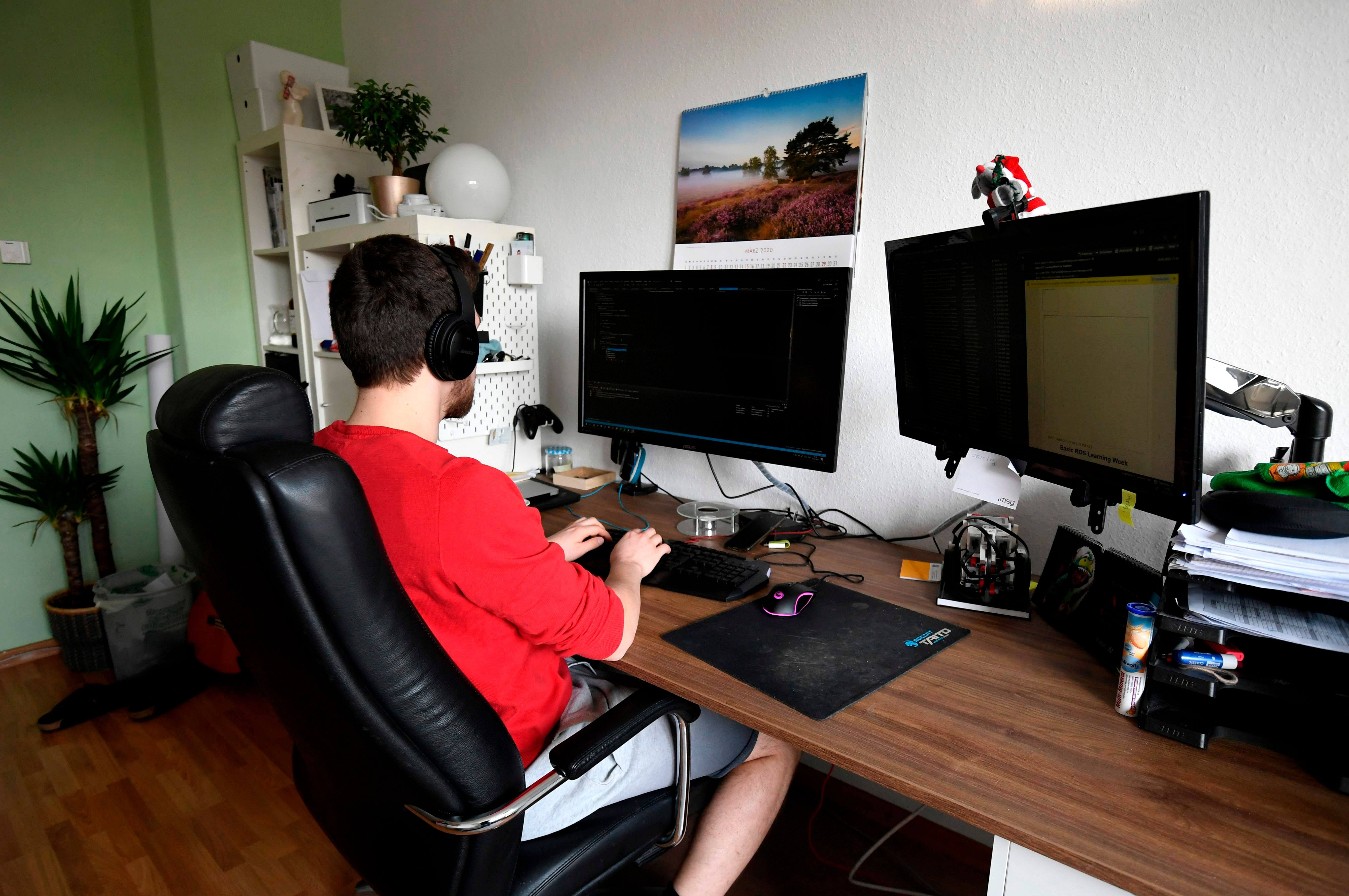 Student Thilo makes home-office for his computer science job in his room of a flat-sharing in Dortmund, western Germany. (Credit: AFP Photo)