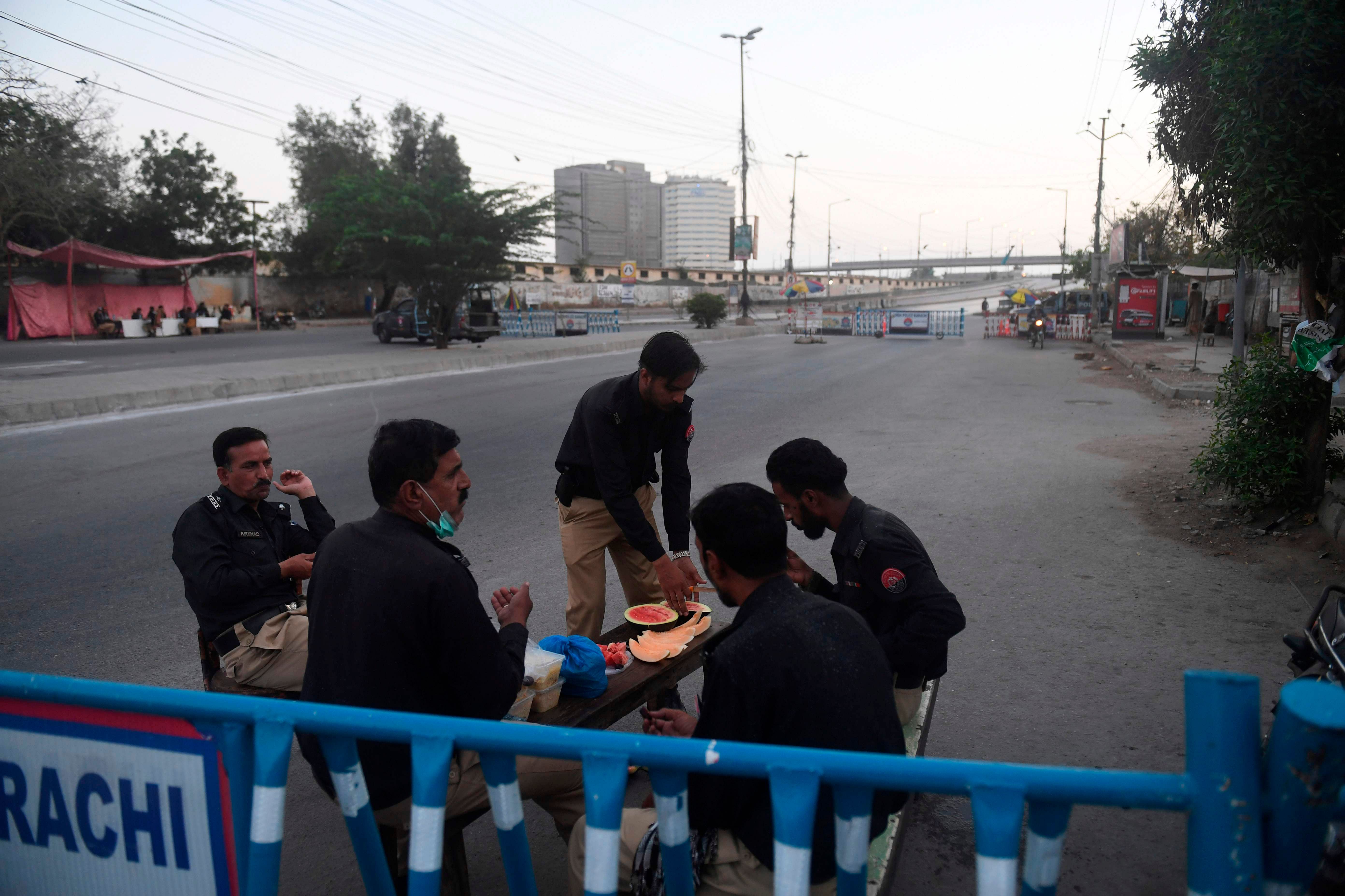 Policemen pray before breaking their fast at a checkpoint on the first day of the Islamic holy month of Ramadan under a government-imposed nationwide lockdown as a preventive measure against the spread of the COVID-19 coronavirus in Karachi. (AFP Photo)
