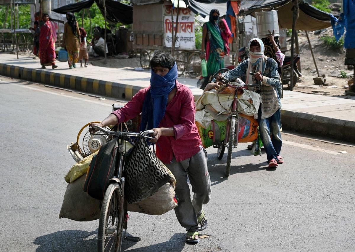  Migrant workers with their belongings walk towards their native place during a government-imposed nationwide lockdown as a preventive measure against the coronavirus, in Prayagraj, Saturday, April 25, 2020. (PTI Photo)