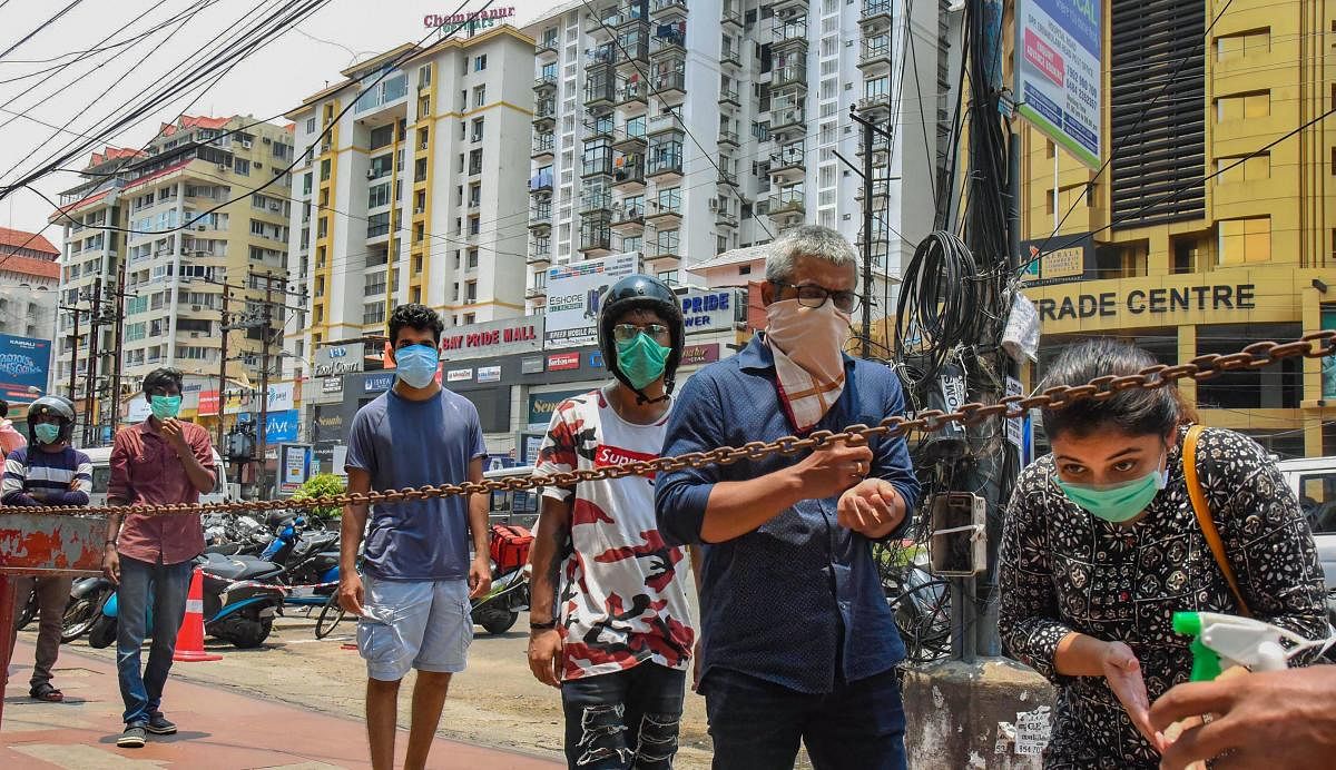 People stand in a queue at a mobile phone shopping complex to purchase and repair mobile phones during the nationwide lockdown in the wake of coronavirus pandemic, in Kochi, Sunday, April 19, 2020. Credit: PTI Photo