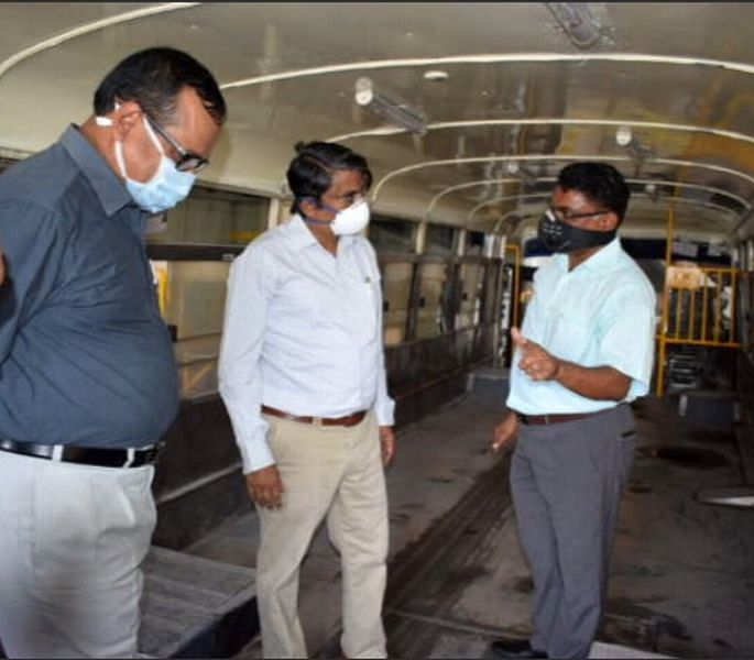 KSRTC Managing Director Shivayogi C Kalasad (centre) inspects construction of the sanitiser bus on Thursday. Credit: DH Photo