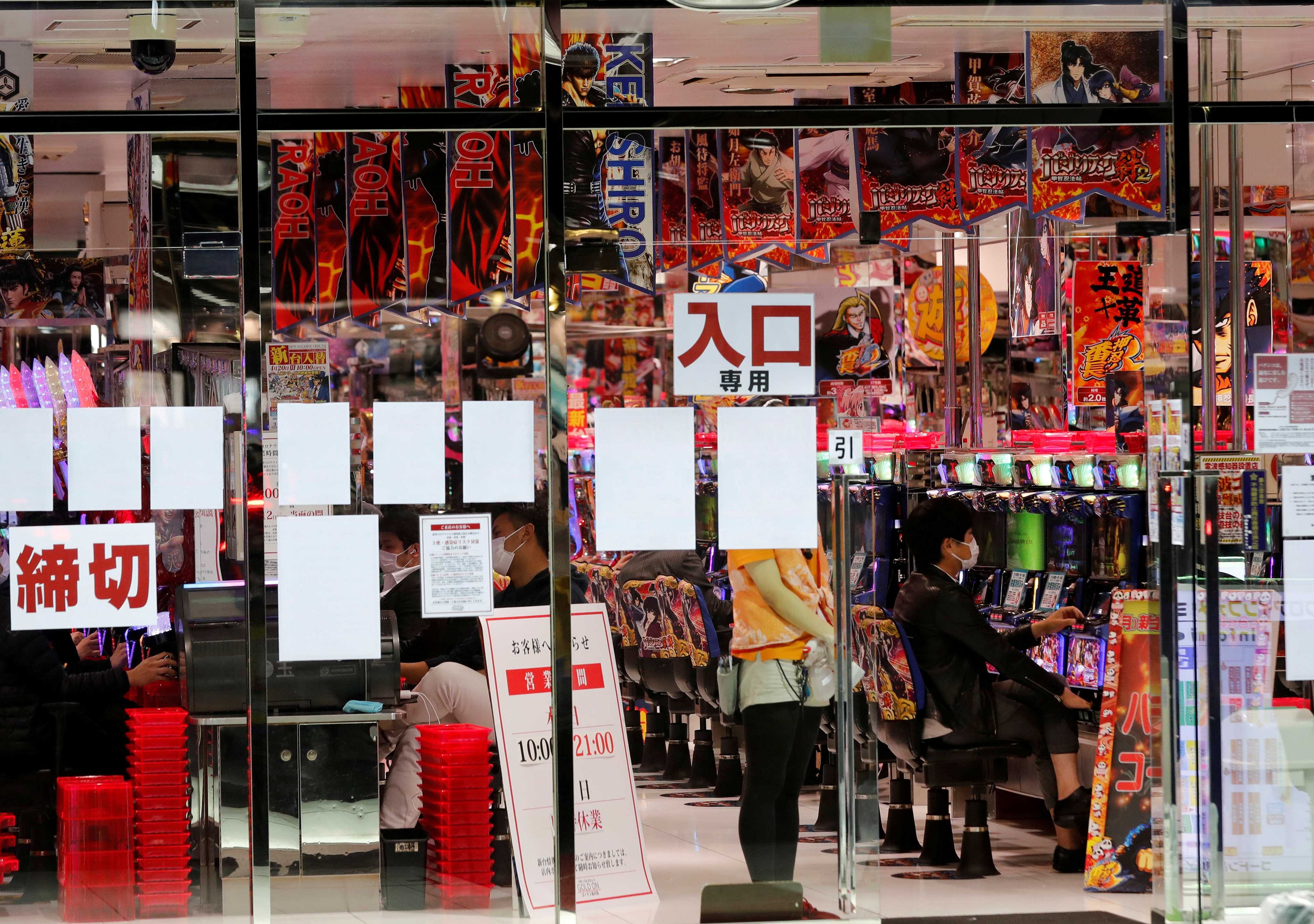 Visitors play pachinko, a Japanese form of legal gambling, at a pachinko parlour, after the government announced nationwide state of emergency following the coronavirus disease (COVID-19) outbreak, in Tokyo. (Credit: Reuters)