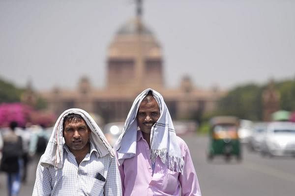 Pedestrians cover their heads to shield from the scorching sun, on a hot summer day, in New Delhi, Monday, June 10, 2019. (PTI Photo/Atul Yadav) 