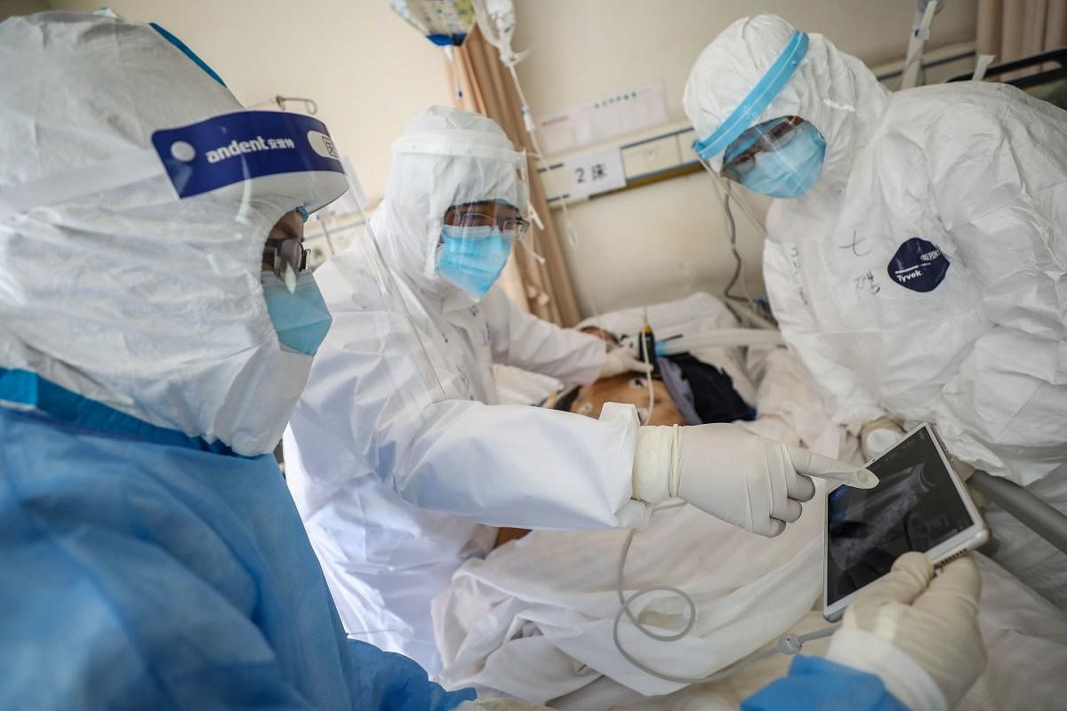 A doctor looking at an image as he checks a patient who is infected by the COVID-19  (AFP Photo)