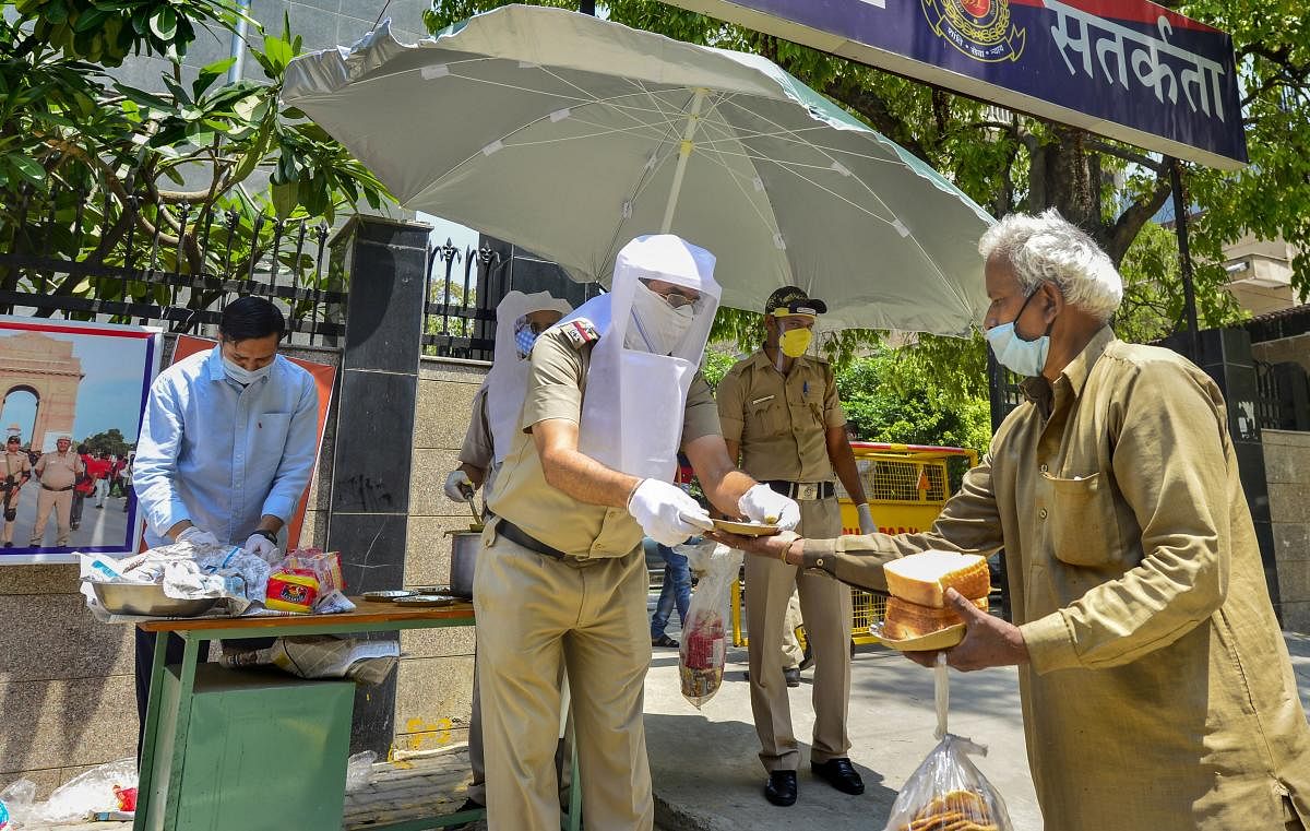 Policemen distribute food among the needy, during the nationwide lockdown to curb the spread of coronavirus, in New Delhi, Monday, April 27, 2020. (PTI Photo)