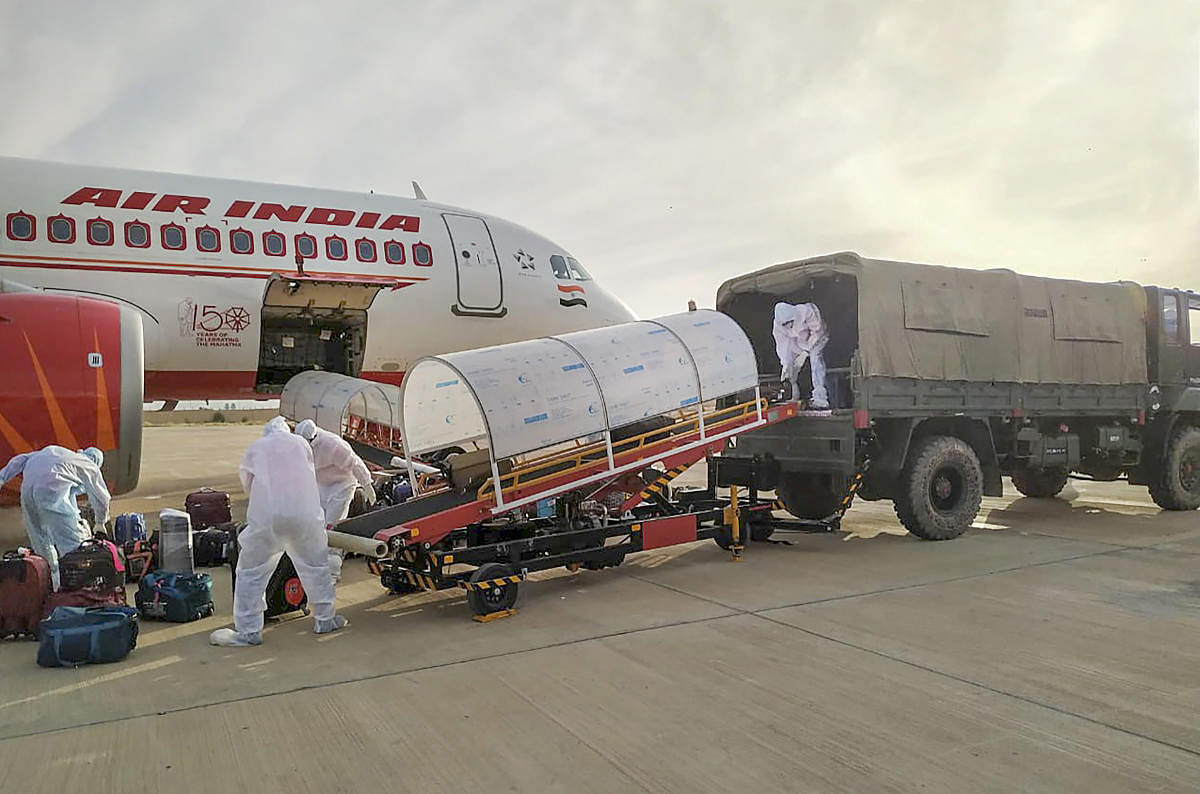 Workers unload the luggage of Indian nationals evacuated from Iran at Jaisalmer Military Station. Two Air India flights carrying over 230 Indians from coronavirus-hit Iran landed. (PTI Photo)