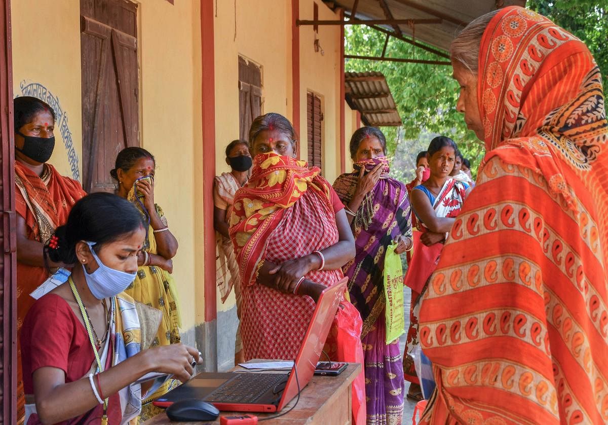 Benficrairies stand in a queue to withdraw money using the mobile bank service introduced by State Bank of India during the nationwide lockdown, in wake of the coronavirus pandemic, in Dharmanagar, North Tripura, Thursday, April 16, 2020. (PTI Photo)