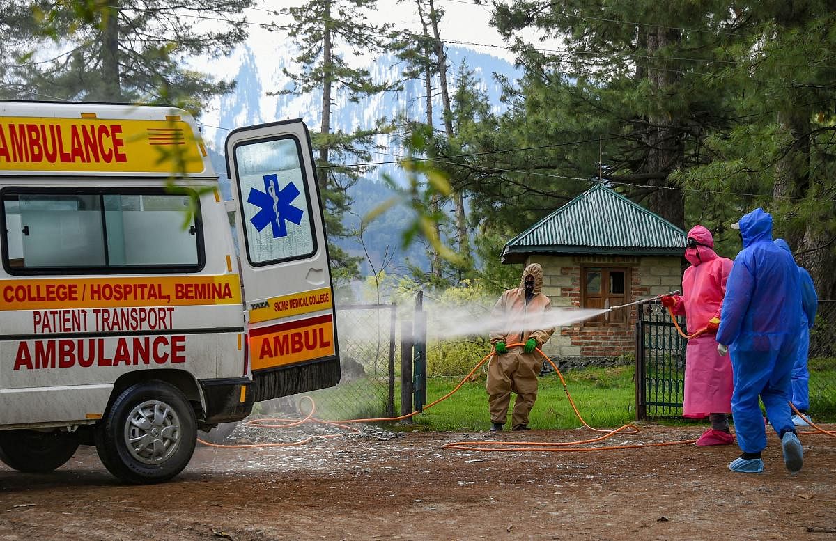 Health officials spray disinfectant on an ambulance that ferried the body of a 72-year-old man who died due to coronavirus, at Tangmarg in Baramulla District of North Kashmir, Saturday, April 25, 2020. (PTI Photo)