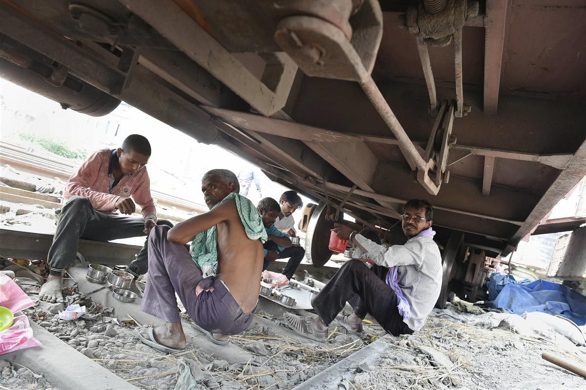 Labourers are seen having their meal beneath a wagon (PTI Phoot)