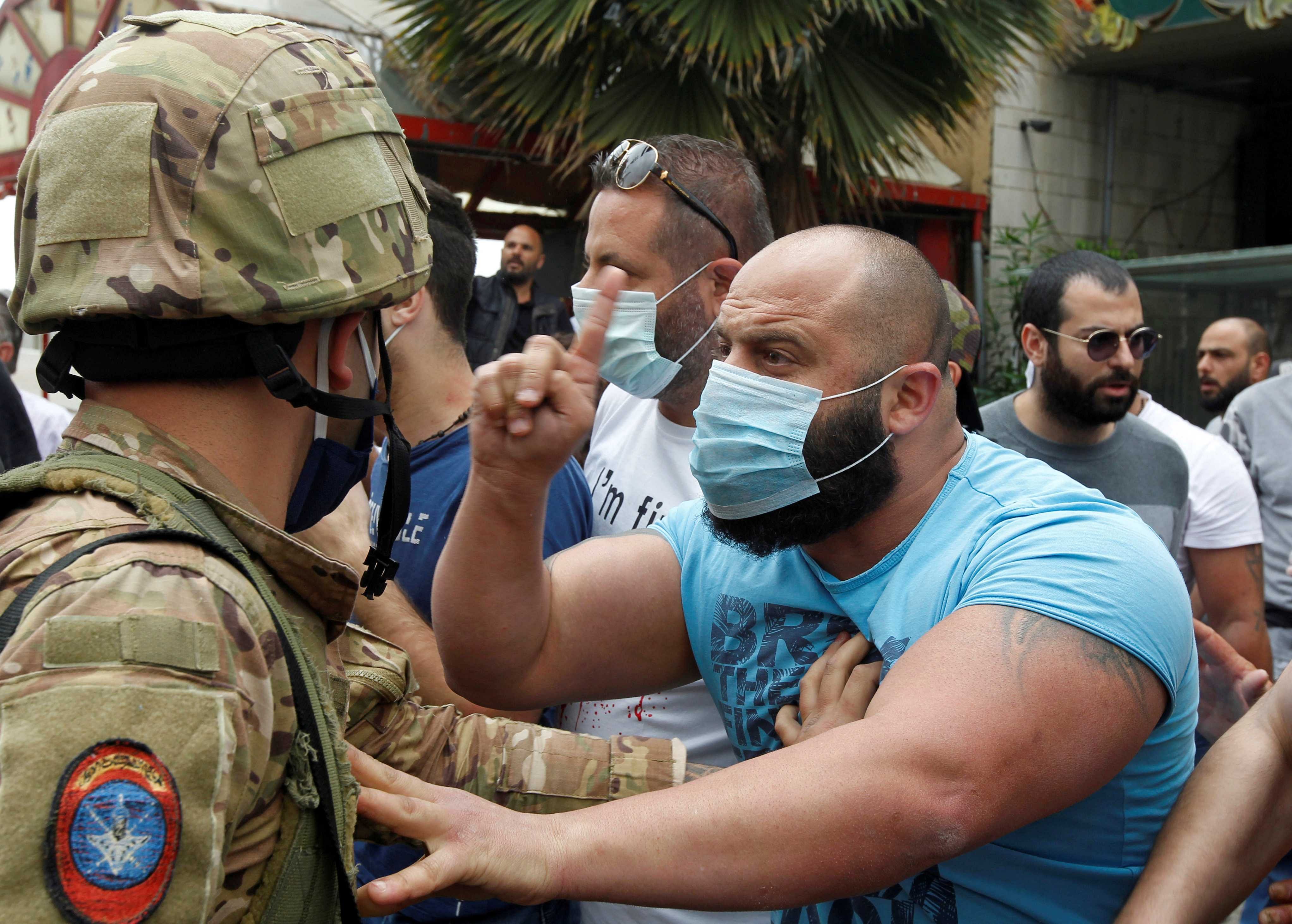 A Lebanese demonstrator gestures to a Lebanese soldier, during a protest against the collapsing Lebanese pound currency and the price hikes, in Zouk, north of Beirut, Lebanon. (Reuters photo)