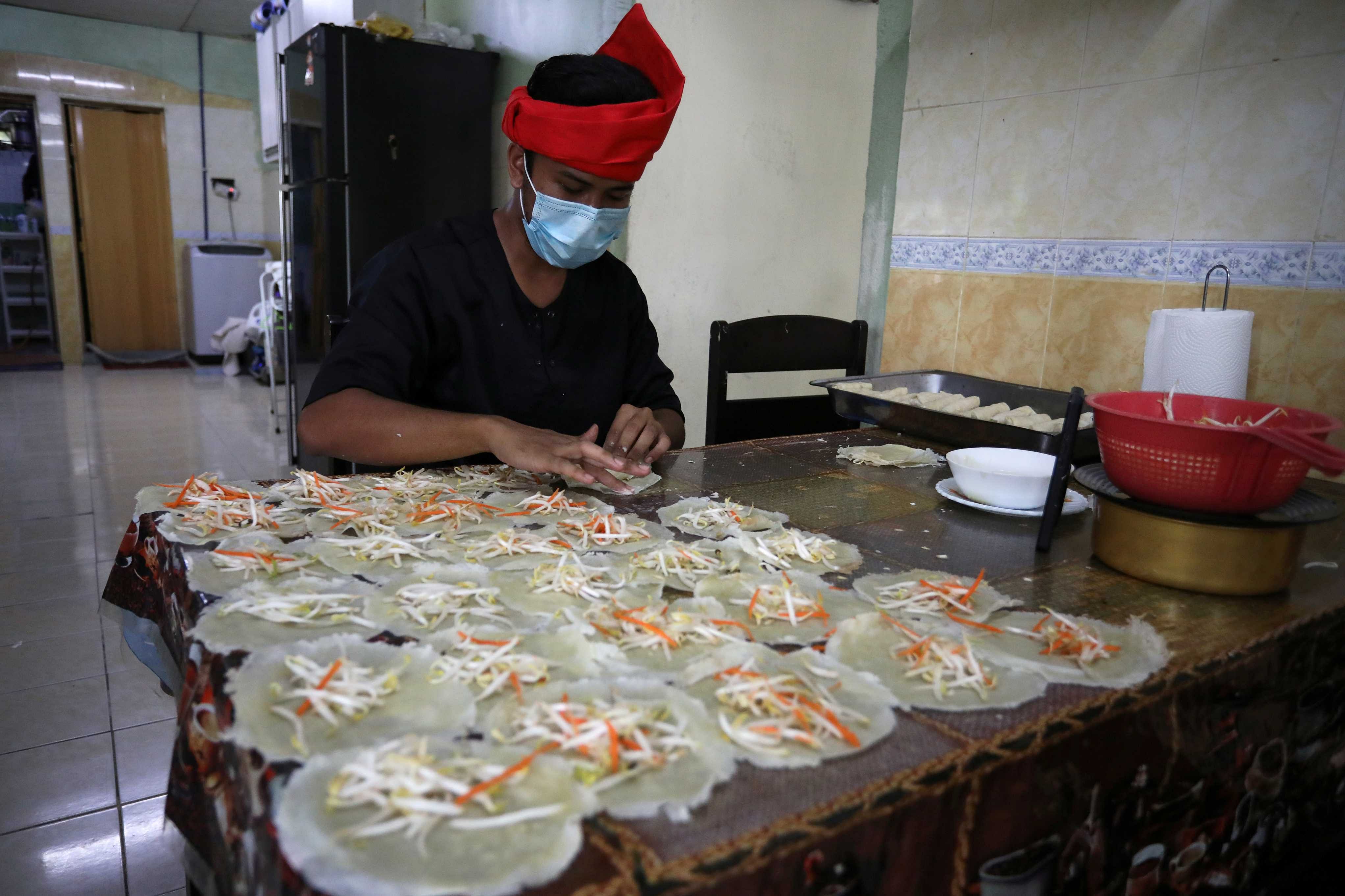 An online Ramadan bazaar trader wraps "Popiah" spring rolls at his home, during the movement control order due to the outbreak of the coronavirus disease (COVID-19), in Sungai Buloh, Malaysia. (Reuters)