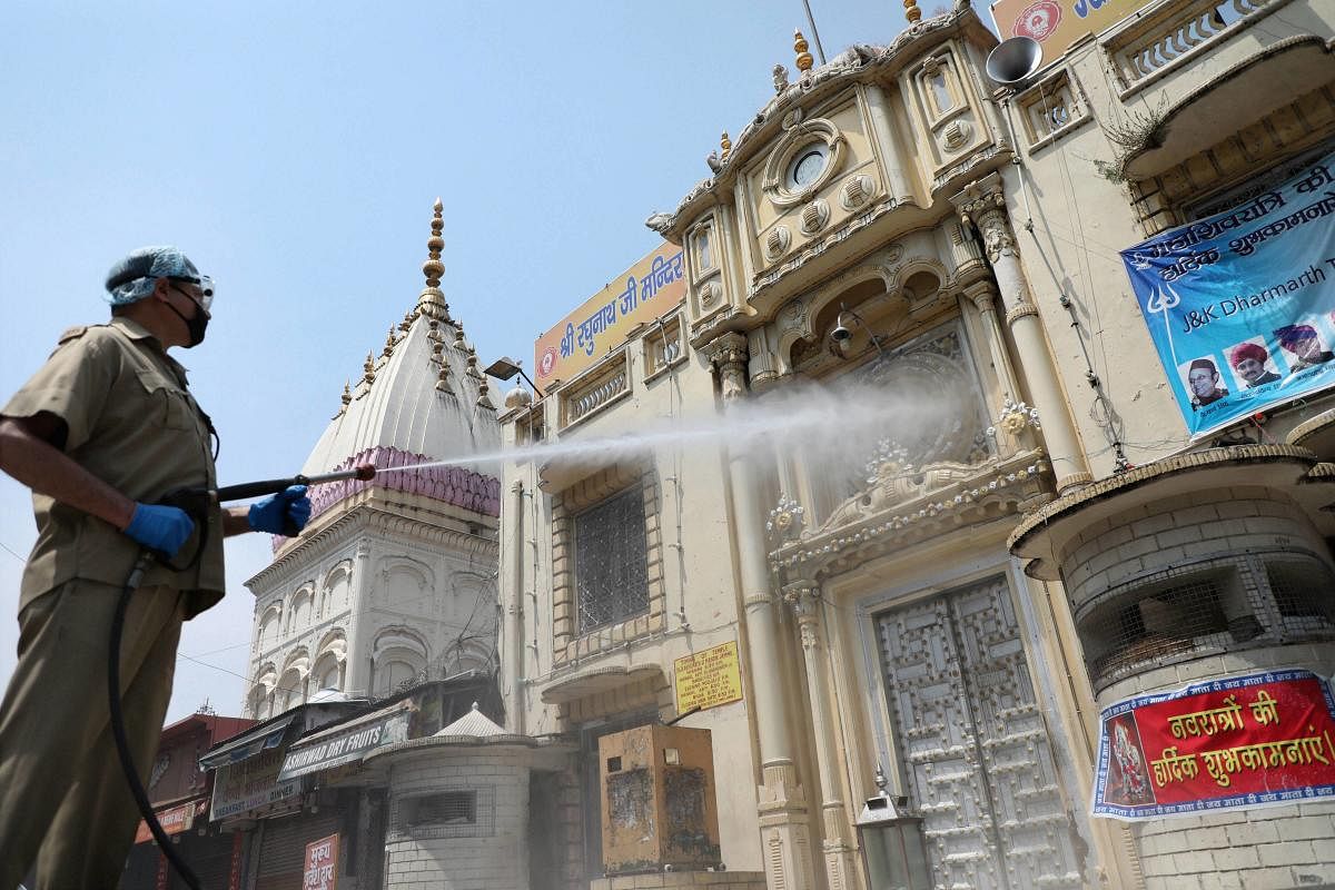  A firefighter sprays disinfectant at Raghunath Bazaar area during a nationwide lockdown in the wake of coronavirus pandemic, in Jammu, Saturday, April 25, 2020. (PTI Photo)