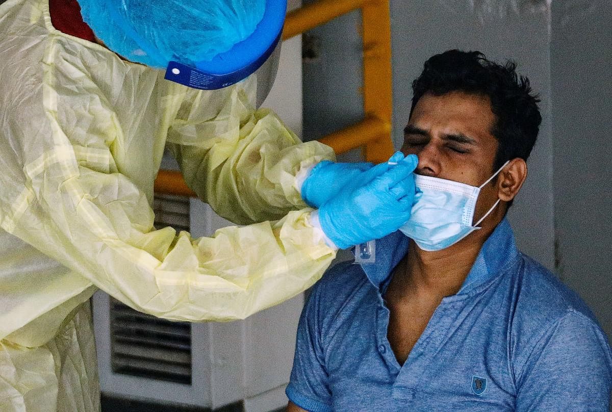 A medical worker performs a nose swab test on a migrant worker at a dormitory amid the coronavirus disease (COVID-19) outbreak in Singapore, April 28, 2020. Credit: Reuters Photo