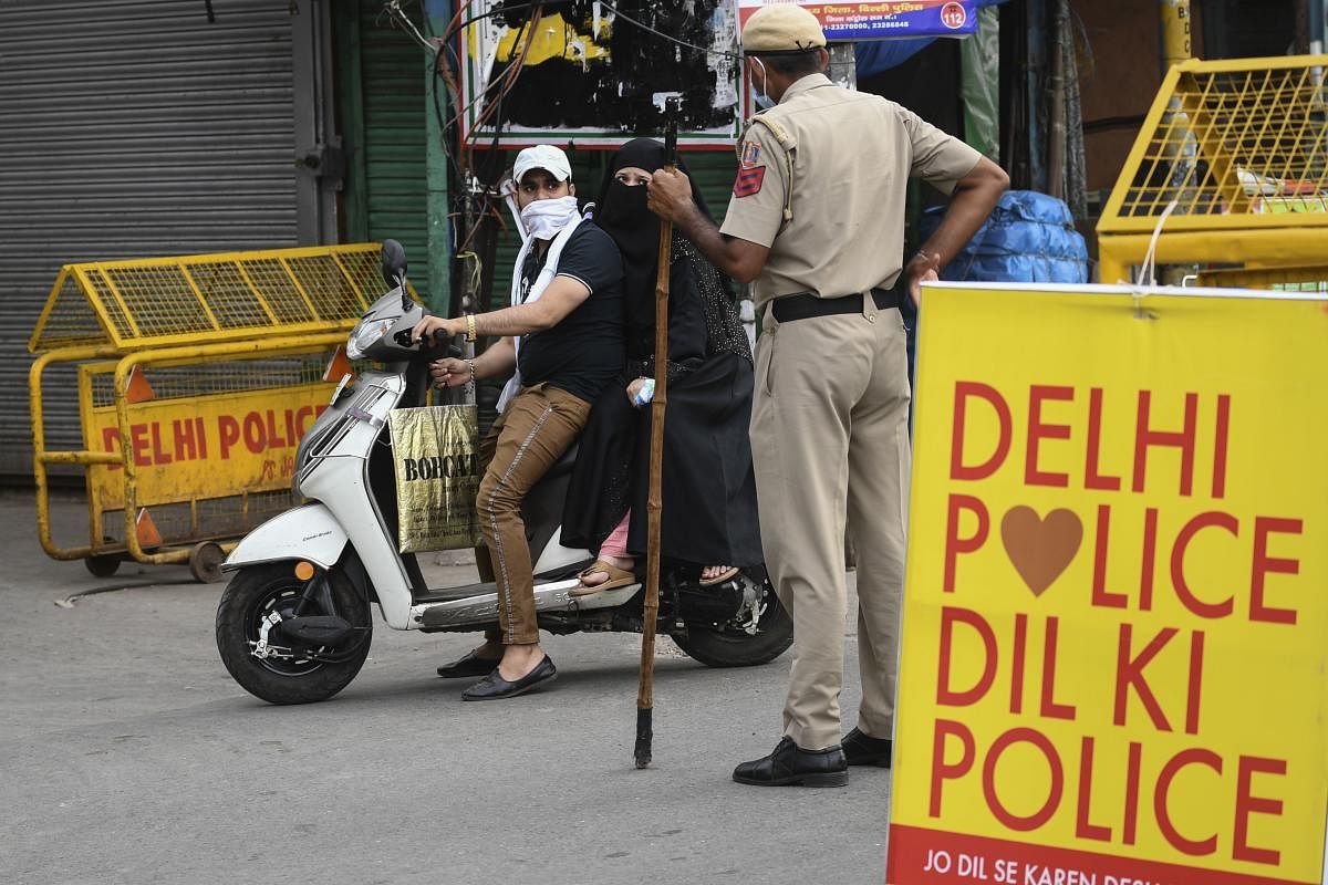A motorist is stoped by a police officer at a checkpoint during a government-imposed nationwide lockdown as a preventive measure against the spread of the COVID-19 coronavirus, in the old quarters of New Delhi on April 23, 2020. Credit: AFP Photo
