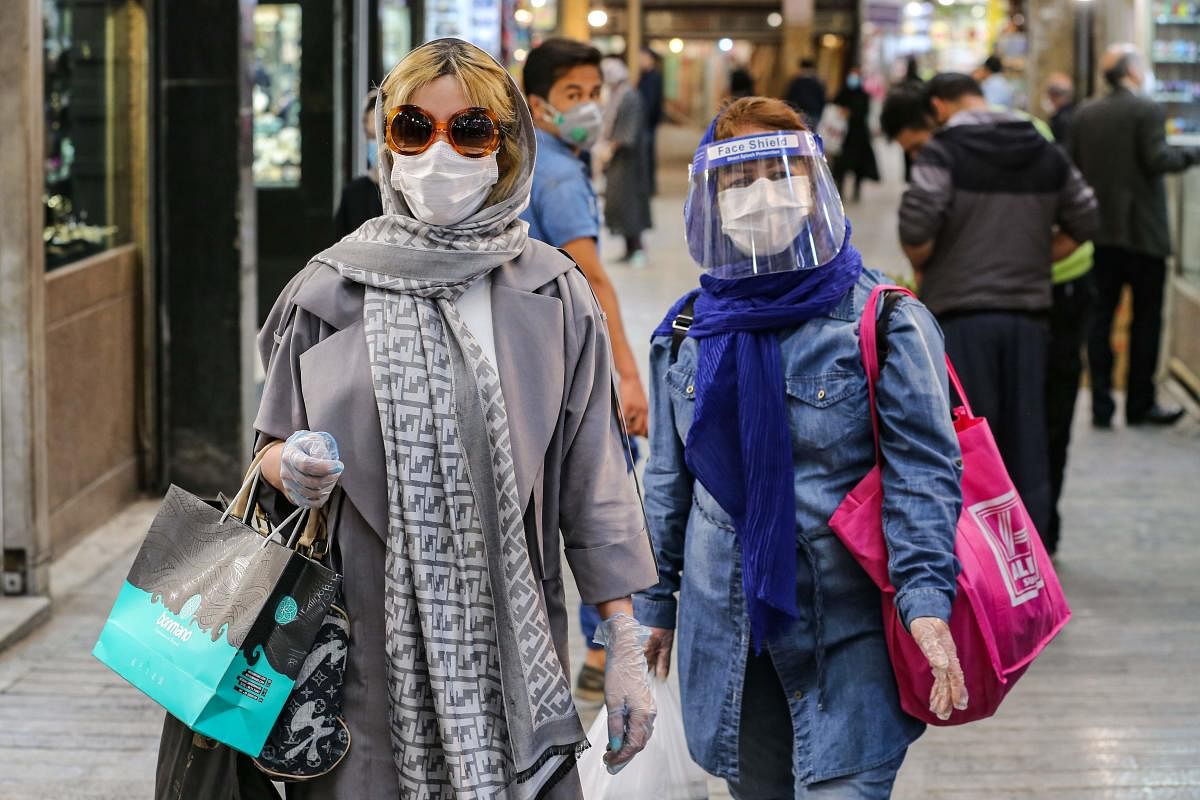 Shoppers clad in protective gear, including face masks and shields and latex gloves, due to the COVID-19 coronavirus pandemic, walk through the Tajrish Bazaar in Iran's capital Tehran on April 25, 2020. Credit: AFP Photo