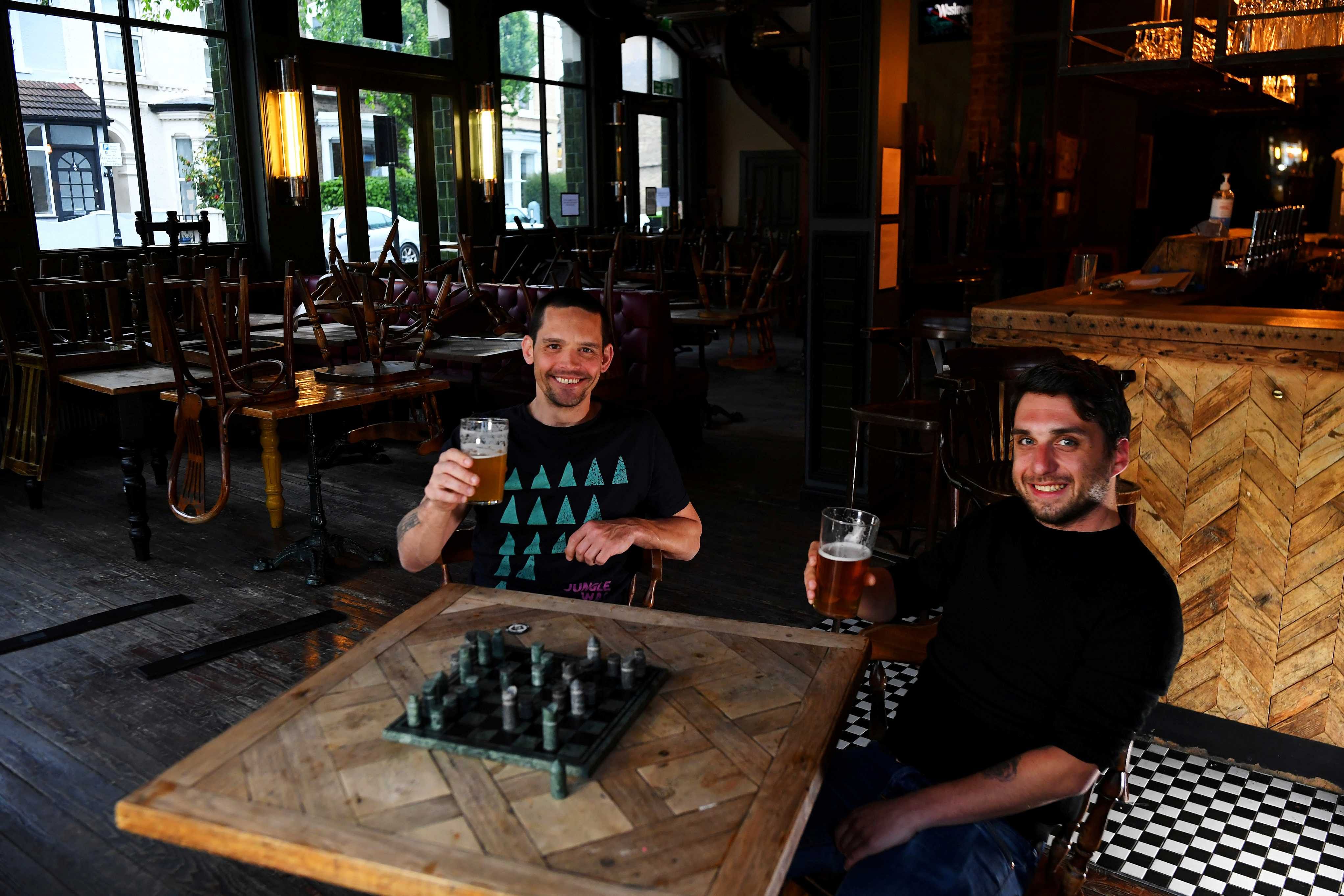 Steve Pond and Dominic Townsend enjoy a pint of beer and a game of chess at The Prince, a pub they share an apartment above and say are lucky enough to be stuck in during lockdown as the coronavirus disease (COVID-19) continues in London, Britain. (Reuters)