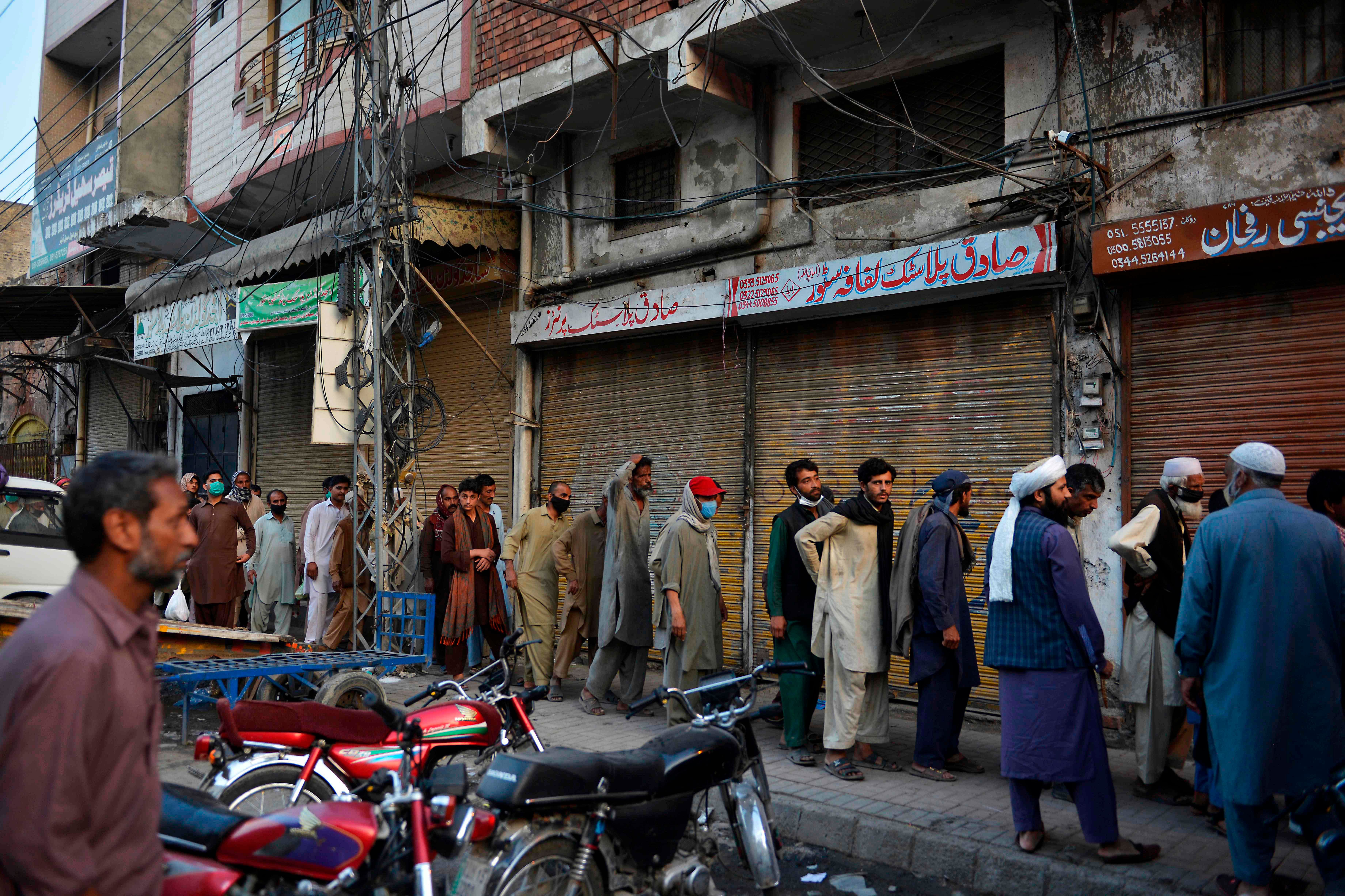Pakistani labourers queue for free iftar food on the Islamic holy month of Ramadan during a government-imposed nationwide lockdown as a preventive measure against the COVID-19. (AFP Photo)