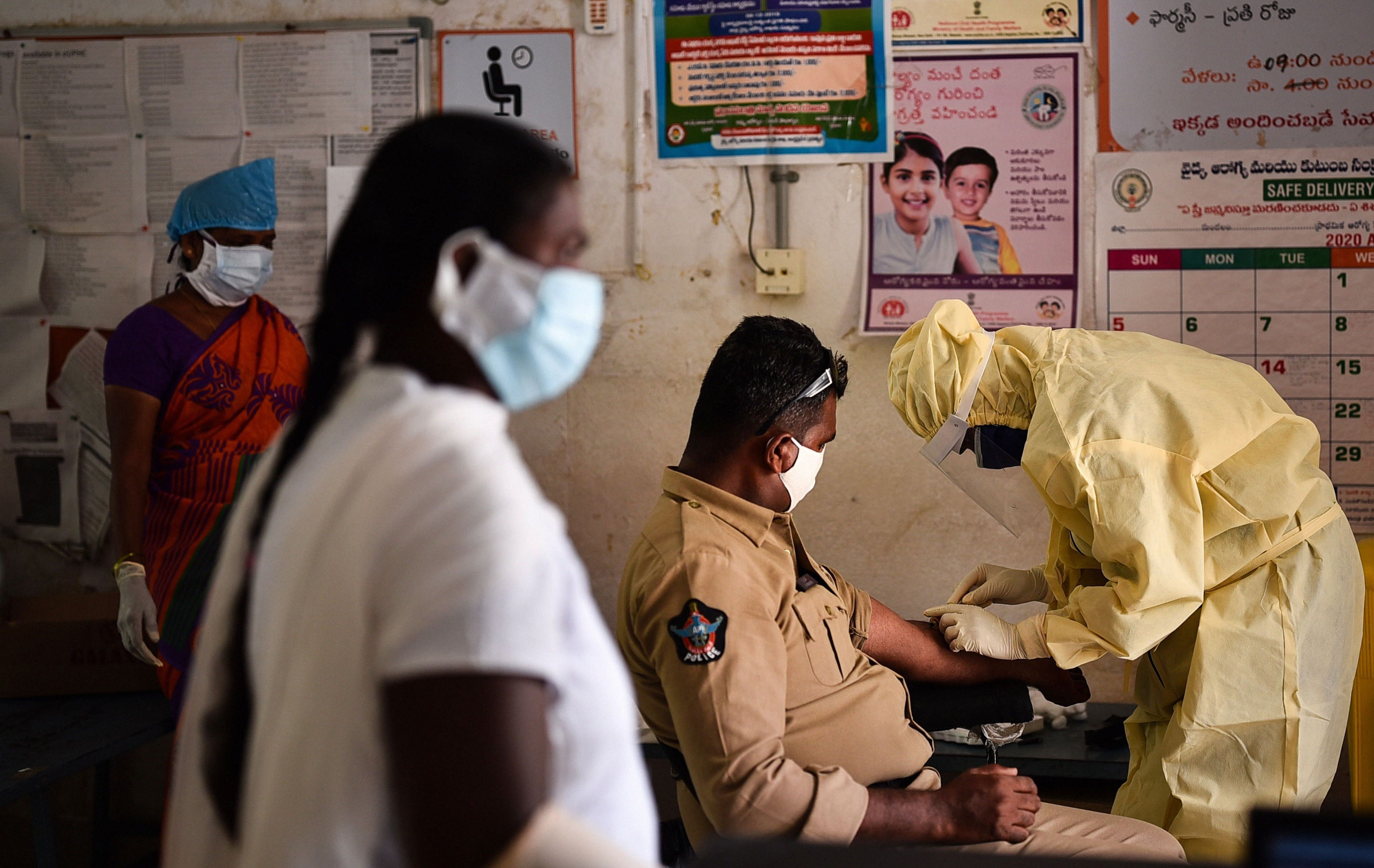 A healthcare worker takes blood sample of a policeman for COVID-19 test in wake of the coronavirus pandemic, in Vijayawada. (PTI Photo)