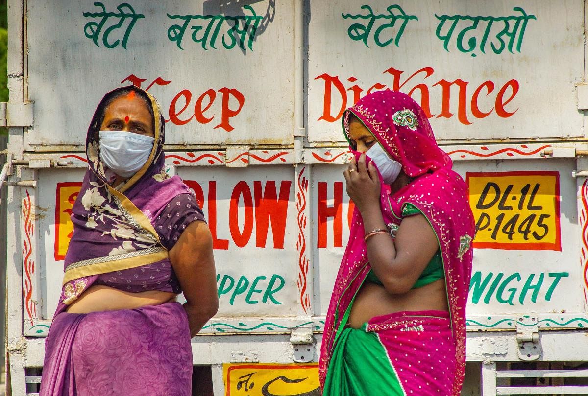 Women wearing masks maintain social distance in a market, during the nationwide lockdown to curb the spread of coronavirus, in New Delhi, Monday, April 27, 2020. Credit: PTI Photo