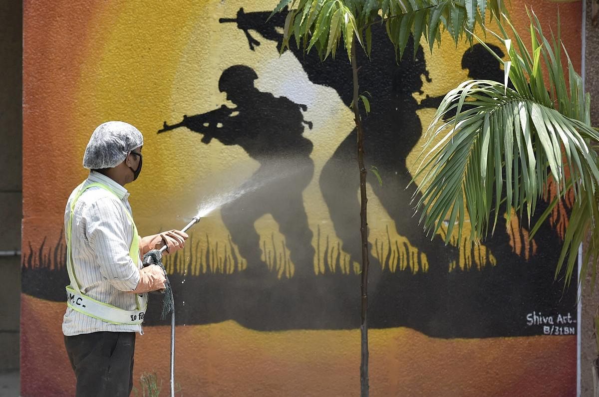 An East Delhi Municipal Corporation (EDMC) worker sprays disinfectant on a wall at CRPF Camp Mayur Vihar, during a nationwide lockdown to curb the spread of coronavirus, in New Delhi, Wednesday, April 29, 2020. Credit: PTI Photo