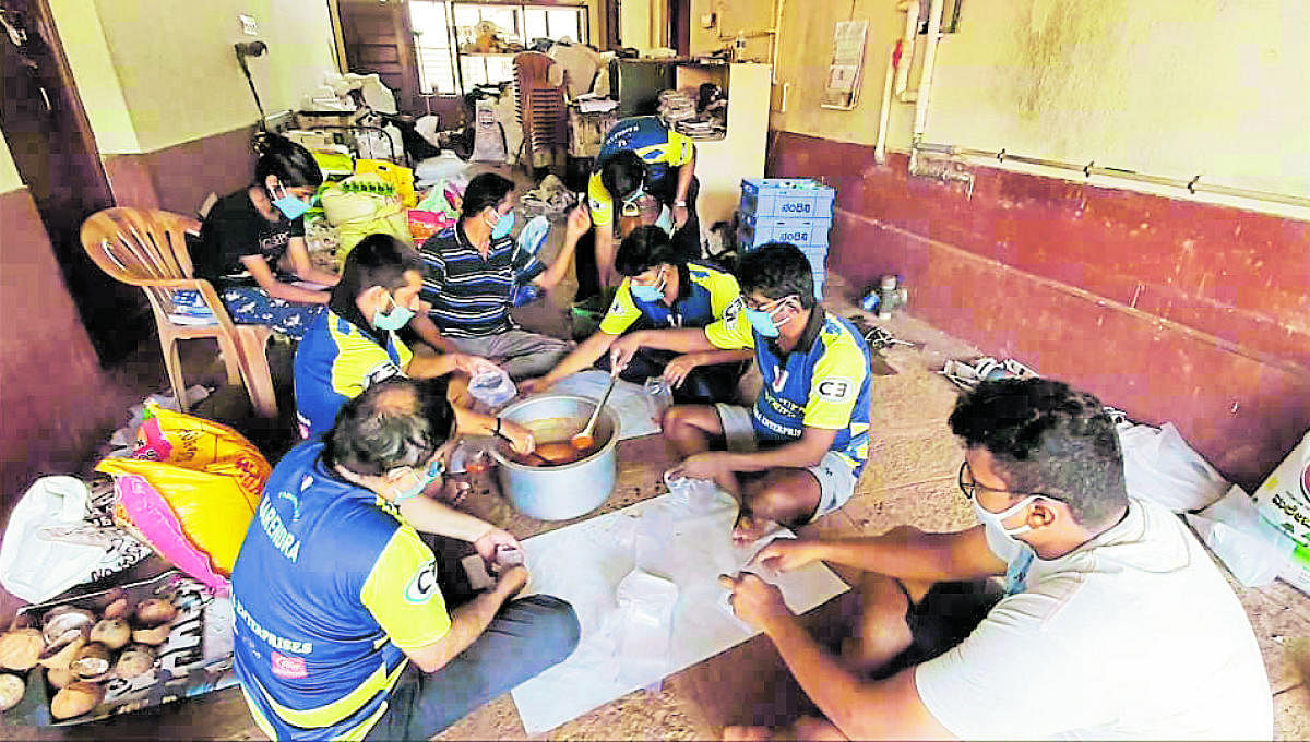 The members of the Padutirupathi cricket team pack the food they have cooked.