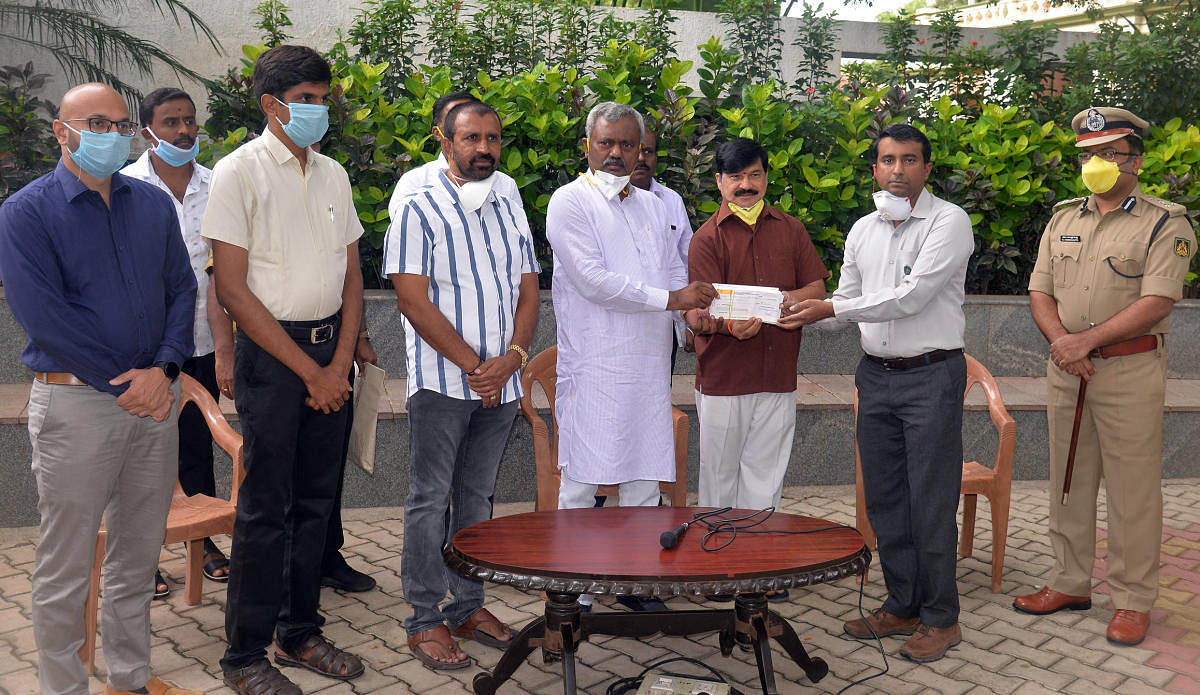 District In-charge Minister S T Somashekar presents a cheque to Executive Director of Mysuru Zoo on Wednesday. MCC Commissioner Gurudatta Hegde, DC Abhiram G Sankar MLAs L Nagendra and S A Ramdas are seen. DH PHOTO