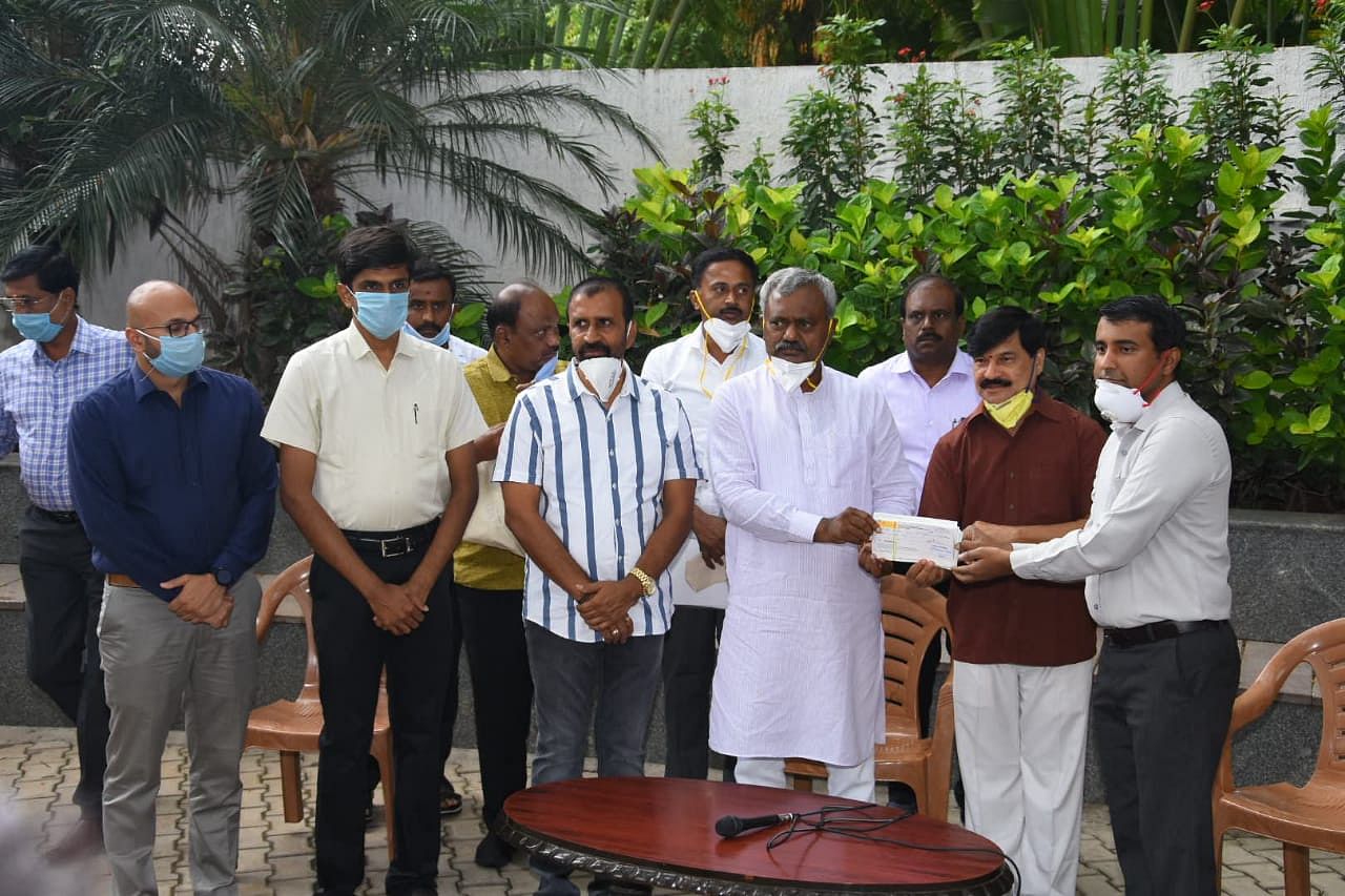 District in-charge Minister S T Somashekar hands over Rs 73.16 lakh cheque to Mysuru Zoo executive director Amit Kulkarni, at Zoo on Wednesday. (Credit: DH Photo)