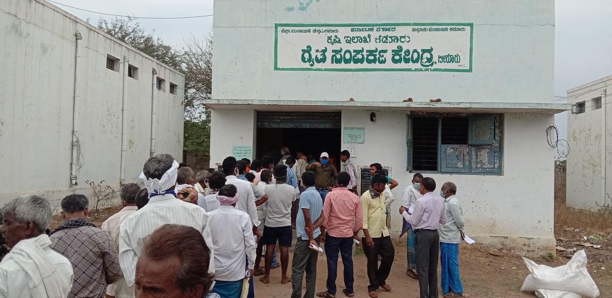 Farmers wait outside the Raitha Samparka Kendra to purchase seeds for cultivation in Birur. DH Photo