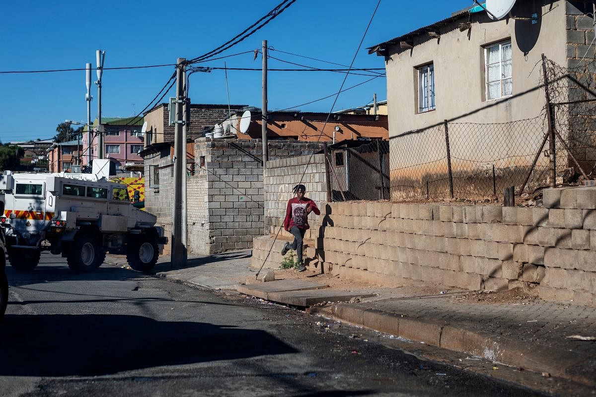 A boy runs away during a mixed patrol of South African National Defence Force (SANDF) and South African Police Service (SAPS) in Alexandra township in Johannesburg. AFP