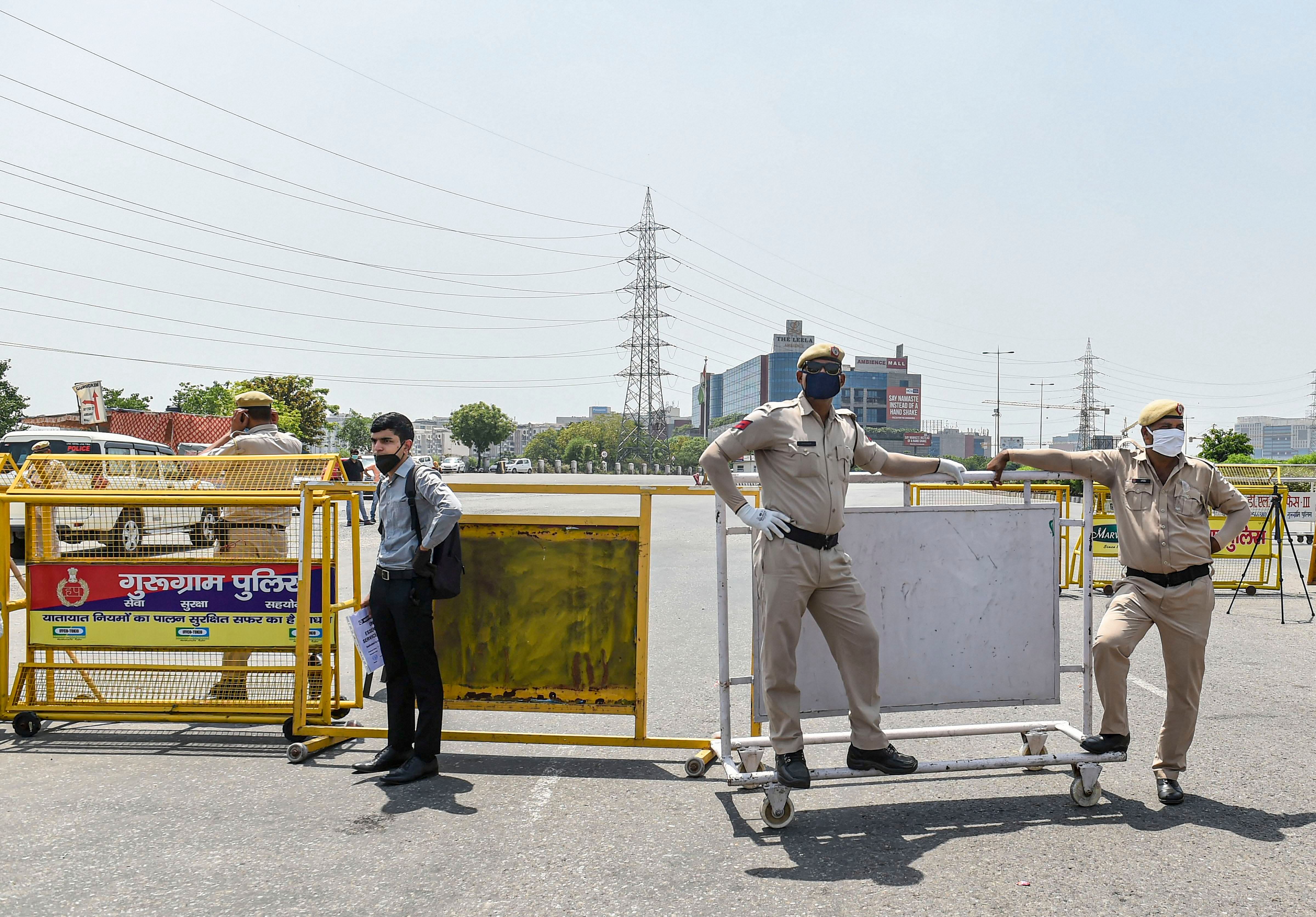 Policemen stand guard near barricades set up after Haryana Government ordered to seal the Delhi-Gurugram border due to surge in COVID-19 cases, during the ongoing nationwide lockdown. (PTI Photo)