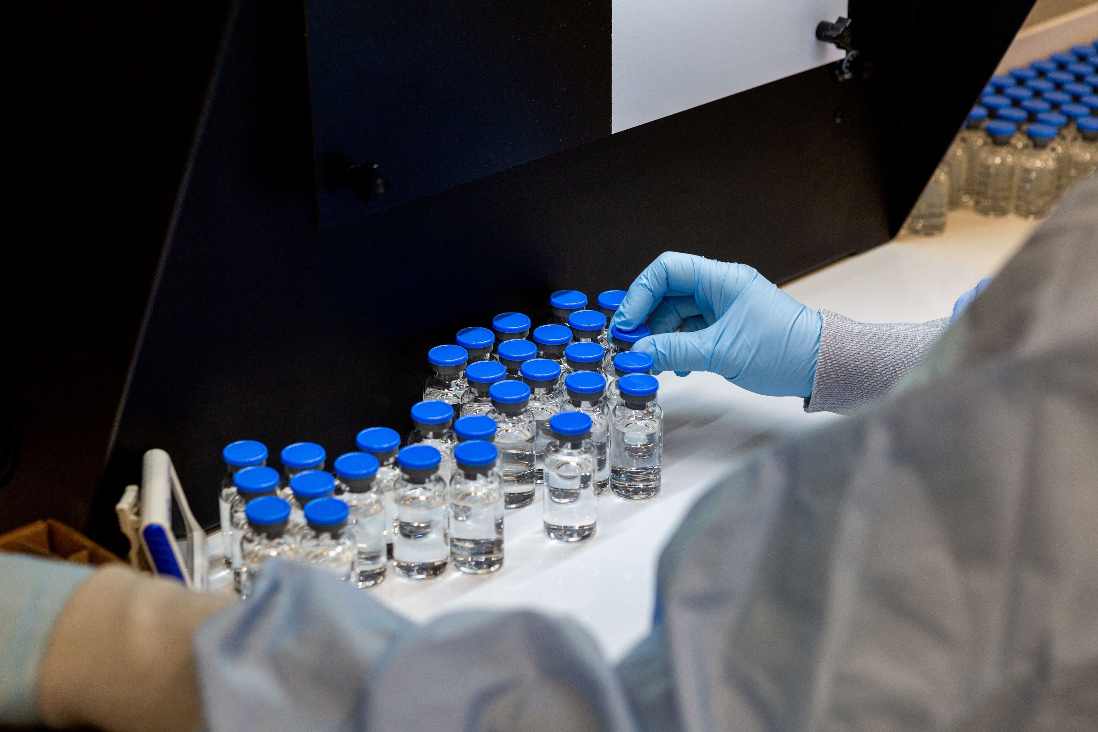 A lab technician inspects filled vials of investigational coronavirus disease (COVID-19) treatment drug remdesivir. (Reuters)