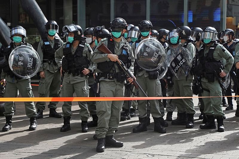 Riot police stand guard as pro-democracy activists gather outside a shopping mall during the Labor Day in Hong Kong. (AP Photo)