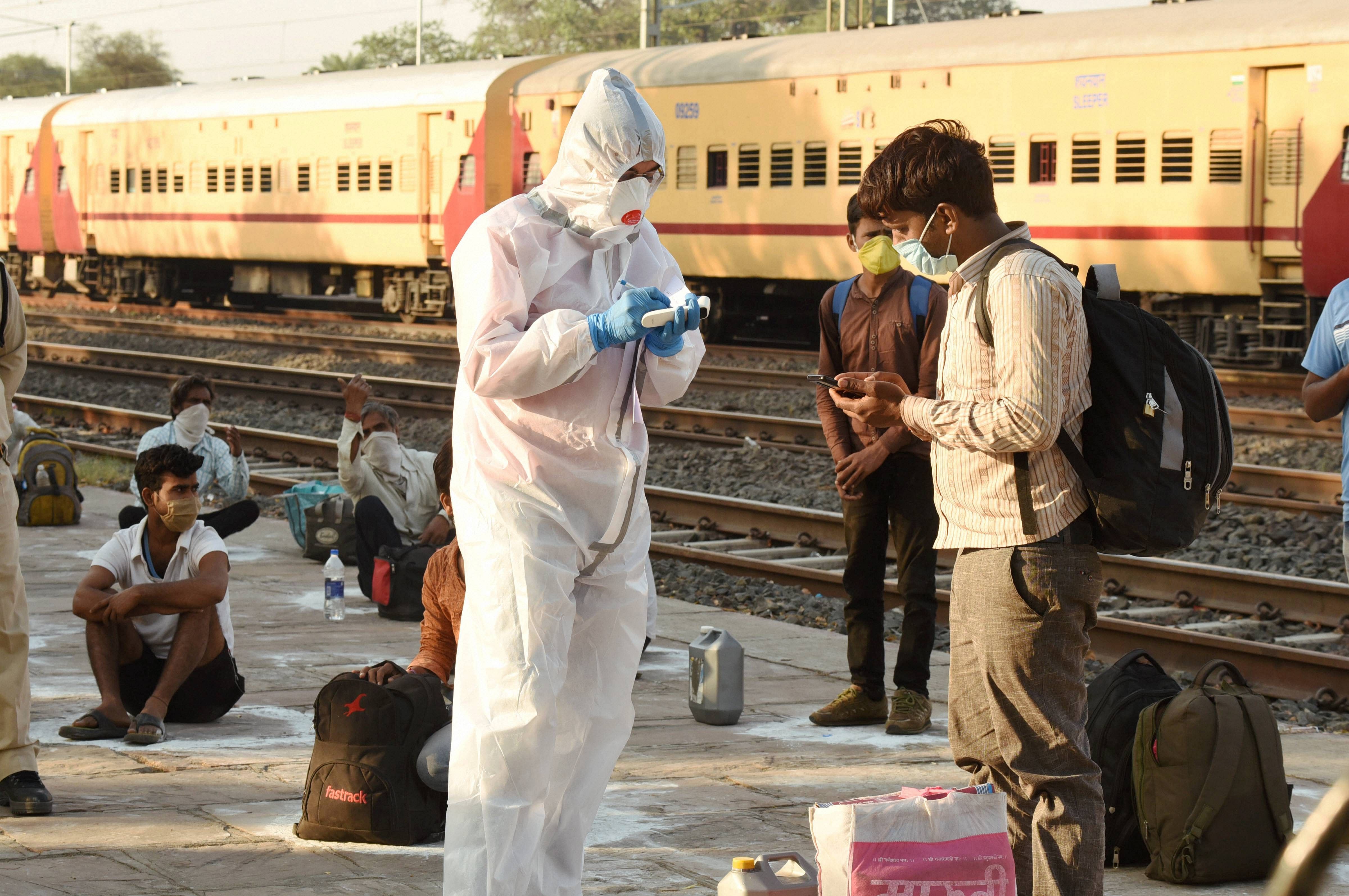 Thermal screening of migrant workers being conducted after they arrive from Nashik by a special train at Misrod railway station, during the ongoing COVID-19 lockdown. (PTI photo)