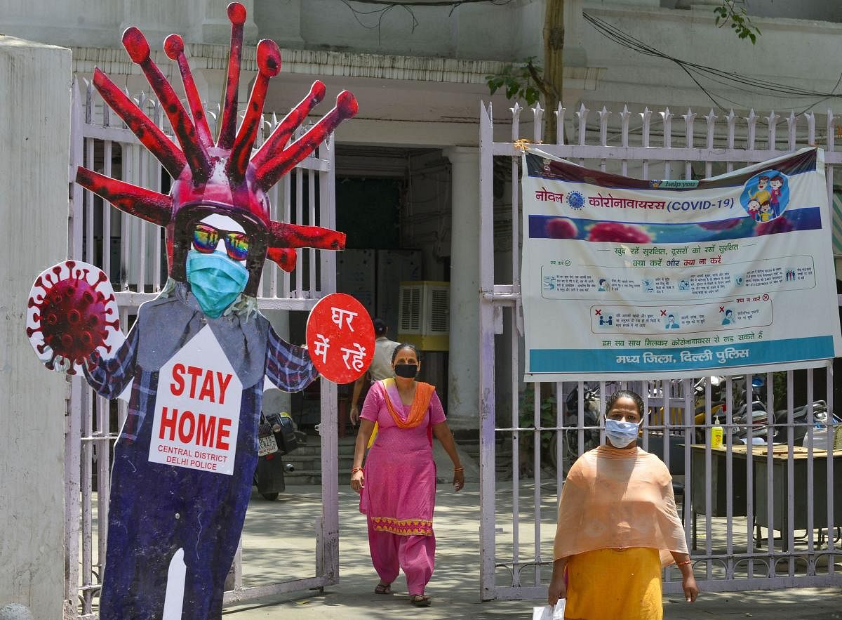 Women walk past a cut-out resembling coronavirus during the ongoing COVID-19 lockdown (PTI Photo)