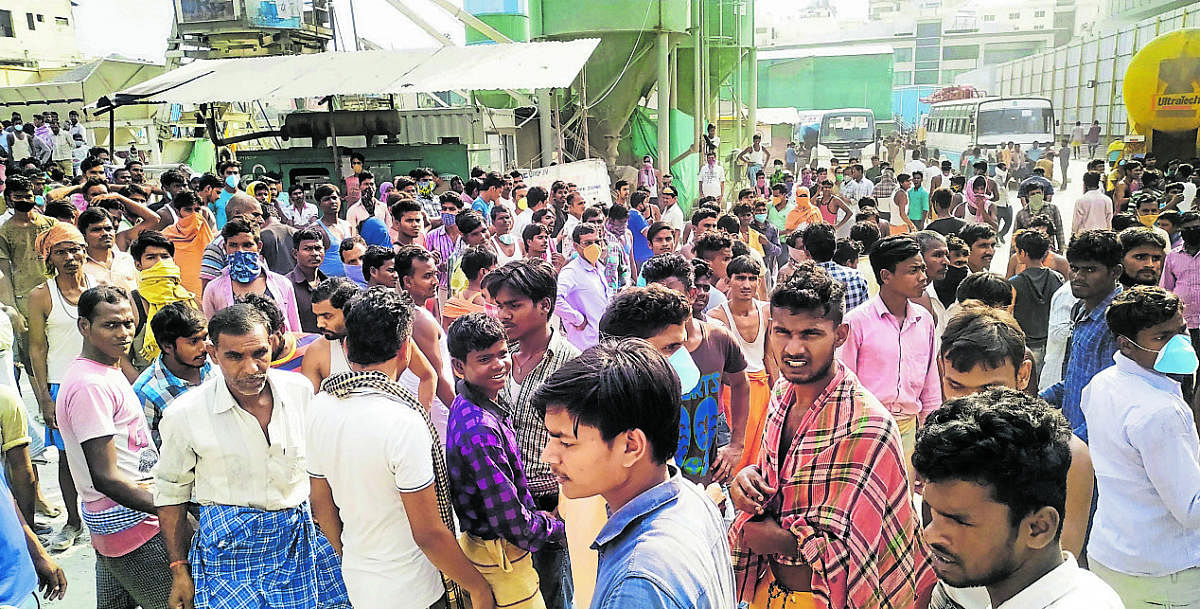 Namma Metro workers gather to stage a protest demanding wages and transportation facilities to return to their home towns. (Credit: DH Photo)