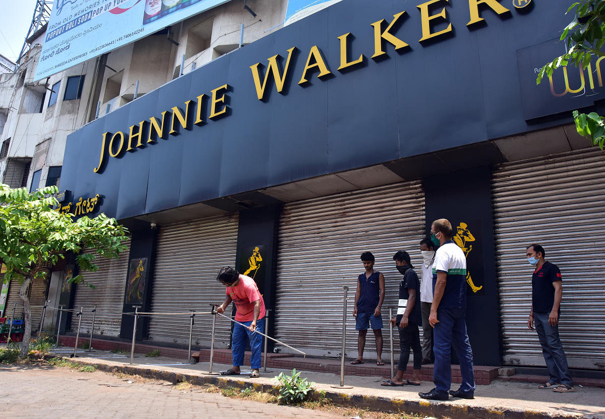 Barricades being placed in front of a retail liquor shop in Balmatta in Mangaluru on Sunday, to ensure that customers do not violate social distancing norms.