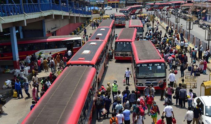 A large number of migrant workers descend at Majestic, Bengaluru, to board KSRTC buses for reaching their hometowns on Sunday. DH Photo/Irshad Mahammad