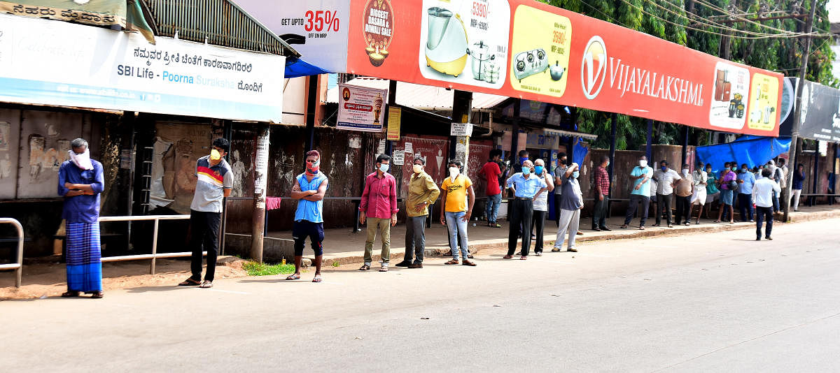 Customers wait for their turn, in the queue before a liquor outlet (not in picture), near Lady Goschen Hospital in Mangaluru on Monday.