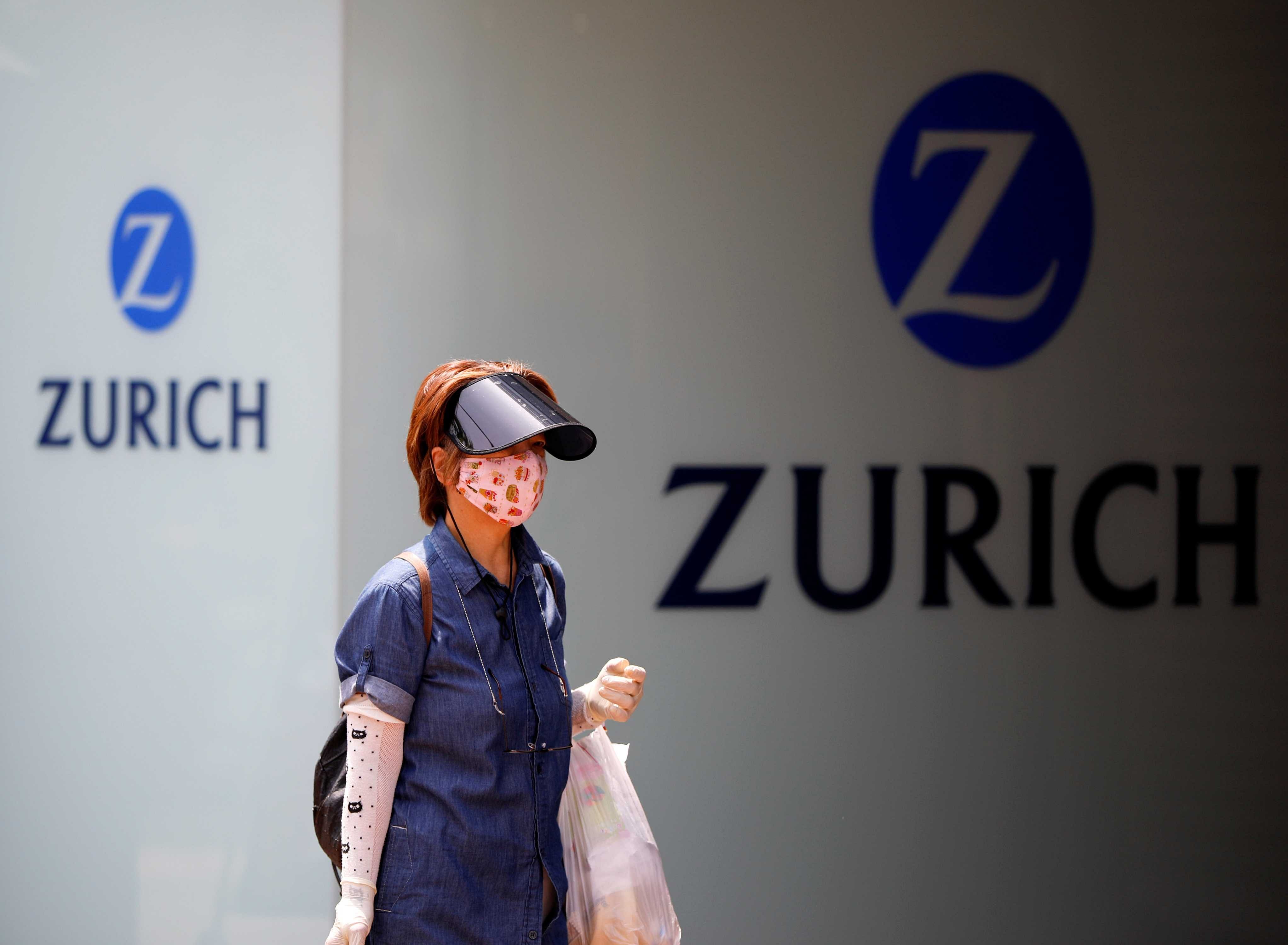 A woman wearing a protective face mask walks past in front of a office building of the Japanese unit of Switzerland's Zurich Insurance Group during a nationwide state of emergency in Tokyo. (Reuters)