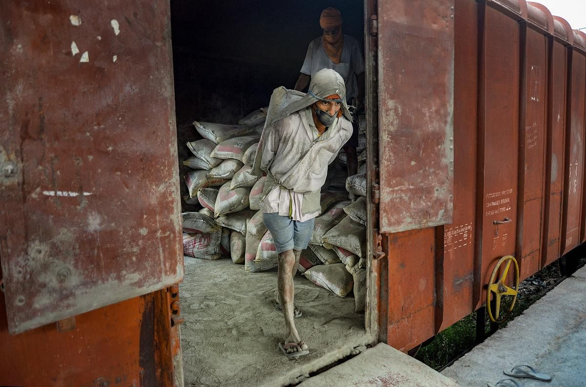 A labourer unloads sacks filled with cement from a wagon, during the nationwide lockdown to curb the spread of coronavirus. PTI