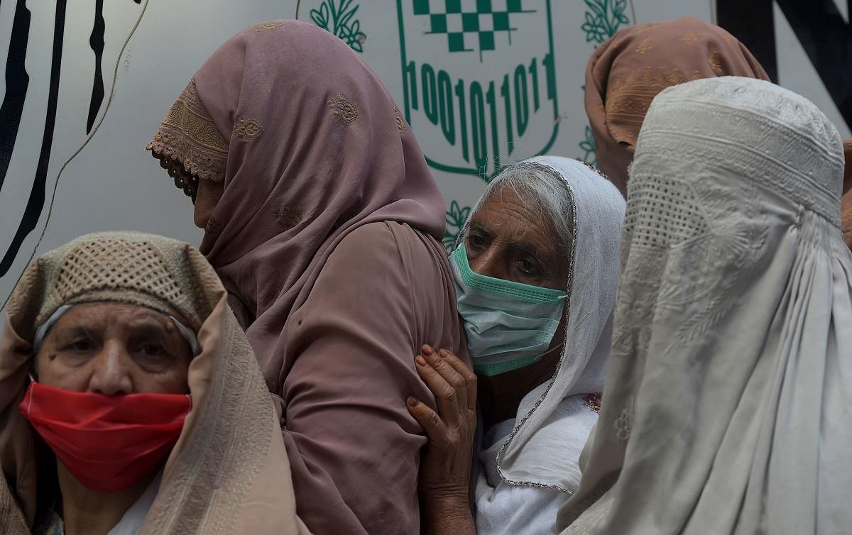 Residents wearing facemasks line up in a queue outside the National Database and Registration Authority (NADRA) office in Pakistan (AFP Photo)