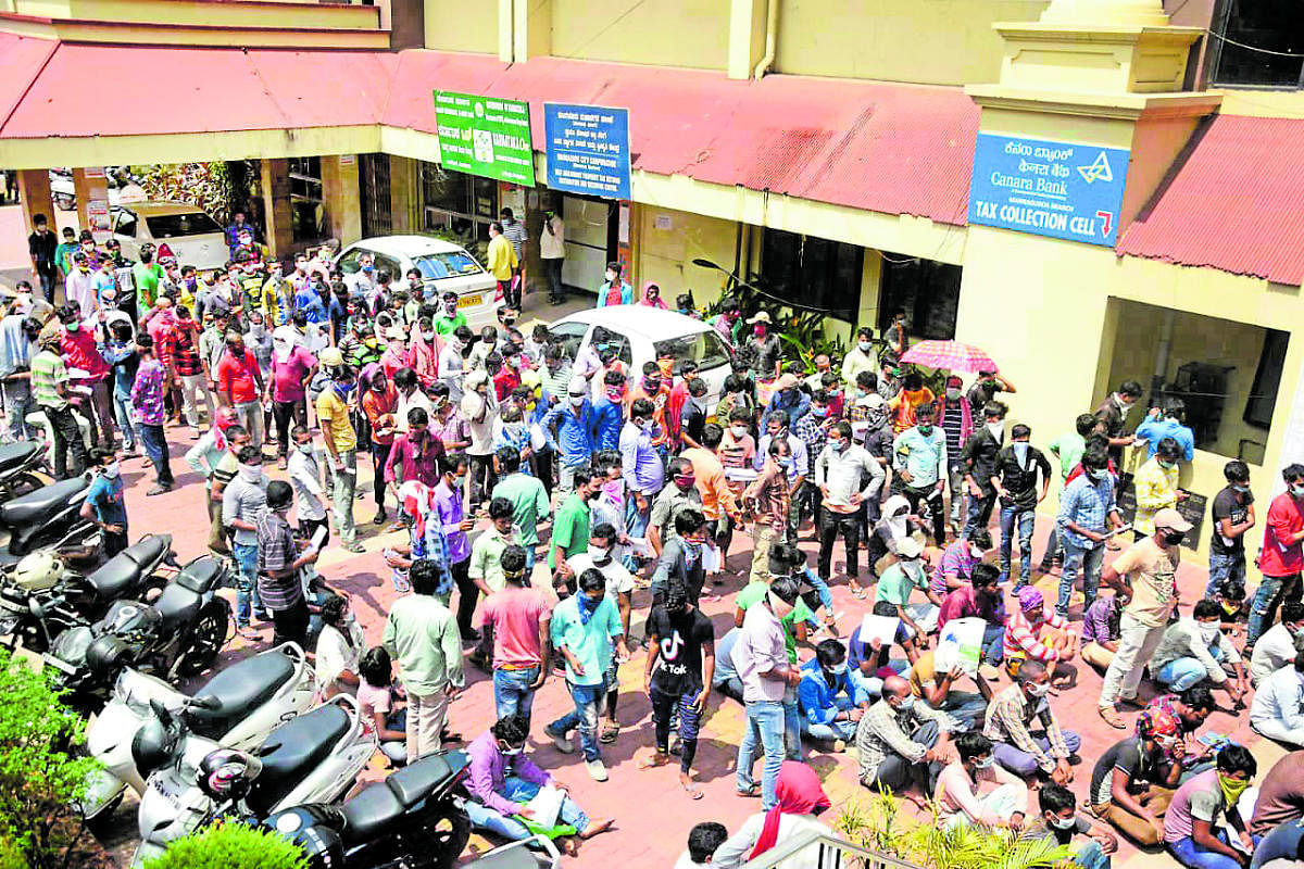 Labourers from outside Karnataka, gathered in front of the MCC building in Lalbagh, seek help in getting a pass to travel to their native places.