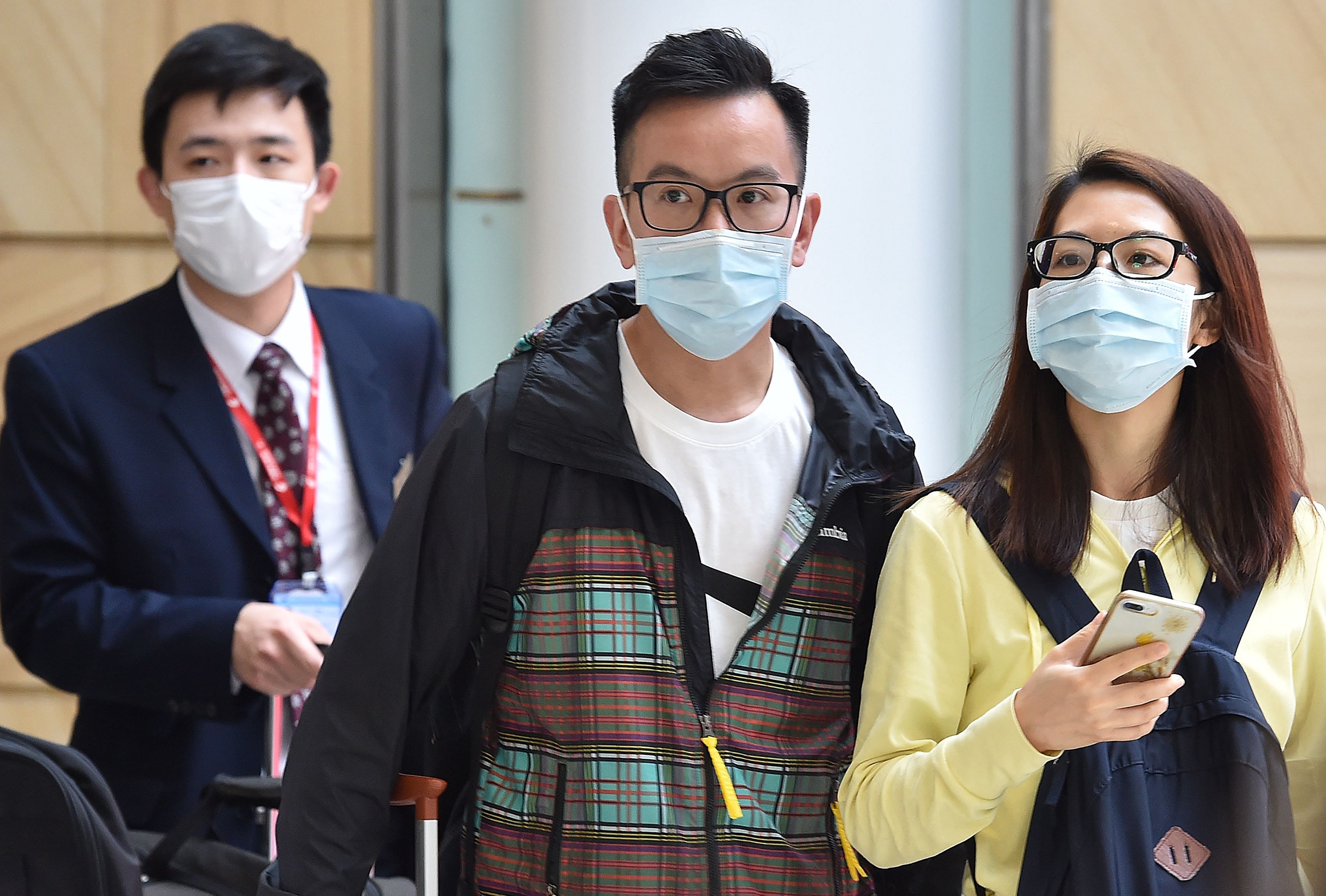 Passangers arrive at Sydney airport wearing masks after landing. (AFP Photo)