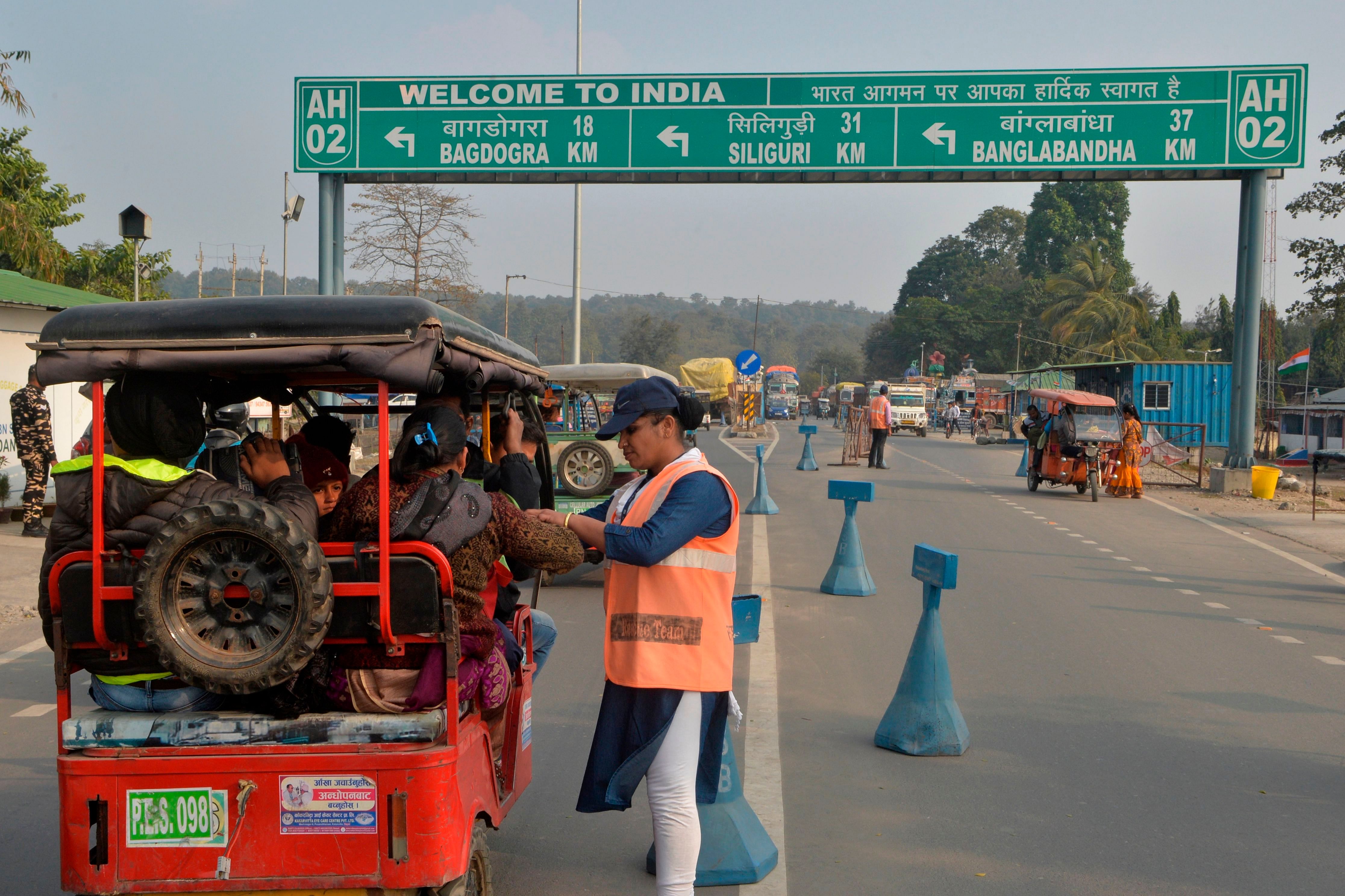 An Indian Sashastra Seema Bal (SSB) personal checks travellers coming from Nepal to India during a Corona virus information camp at an India-Nepal border crossing. (AFP Photo)