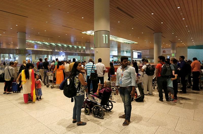 Passengers wait for their luggage at a conveyor belt at the Chhatrapati Shivaji International airport in Mumbai. (Reuters Photo)