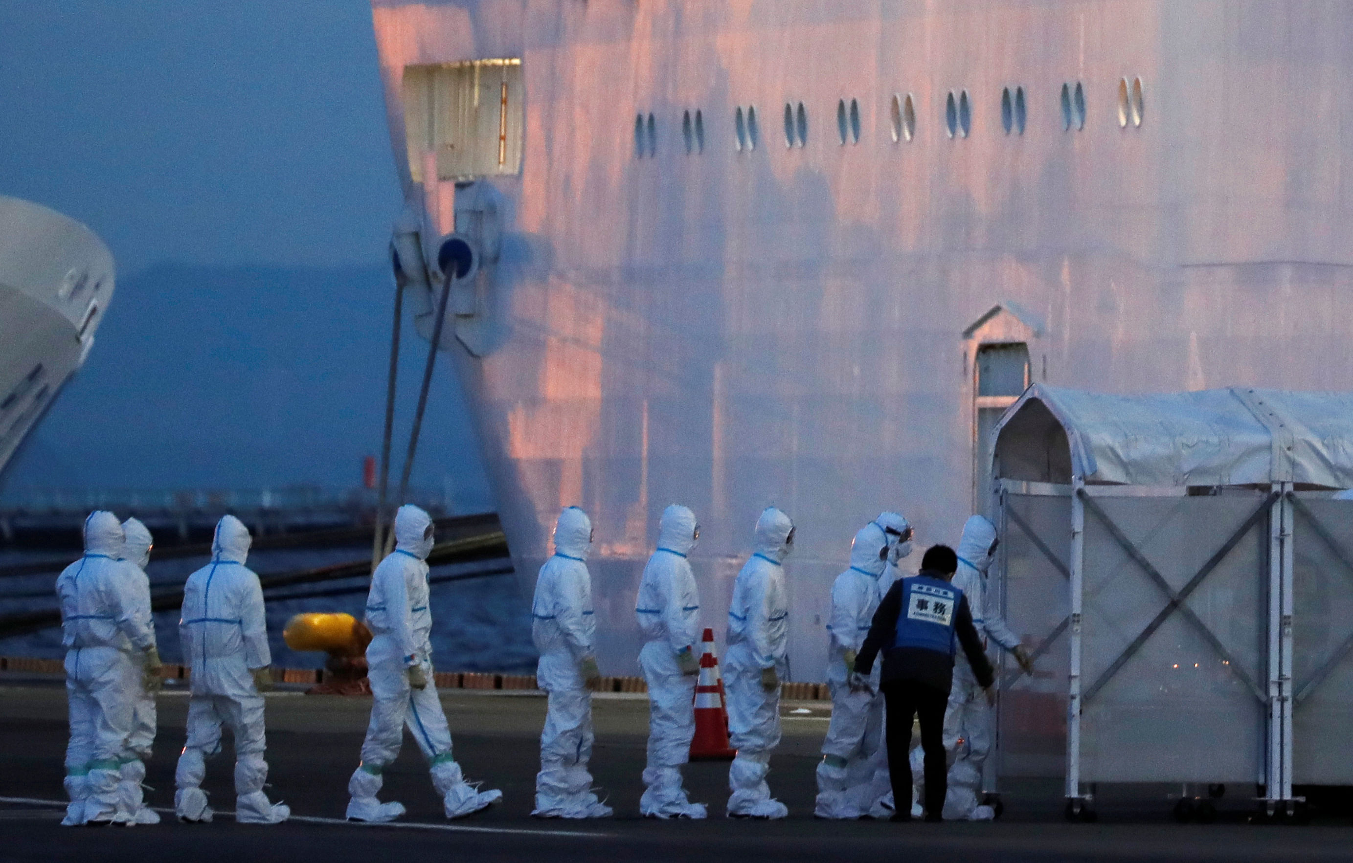 Officers in protective gear enter the cruise ship Diamond Princess, where 10 more people were tested positive for coronavirus on Thursday, after the ship arrived at Daikoku Pier Cruise Terminal in Yokohama, south of Tokyo, Japan. (Reuters Photo)