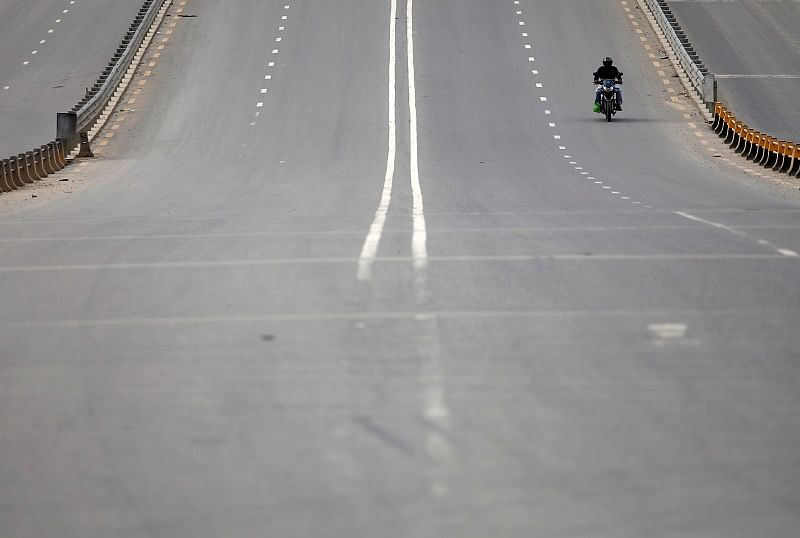 A man rides on an empty street as long distance bus and land border crossings are shut down amid concerns about the spread of coronavirus disease (COVID-19), in Kathmandu, Nepal. (Reuters Photo)