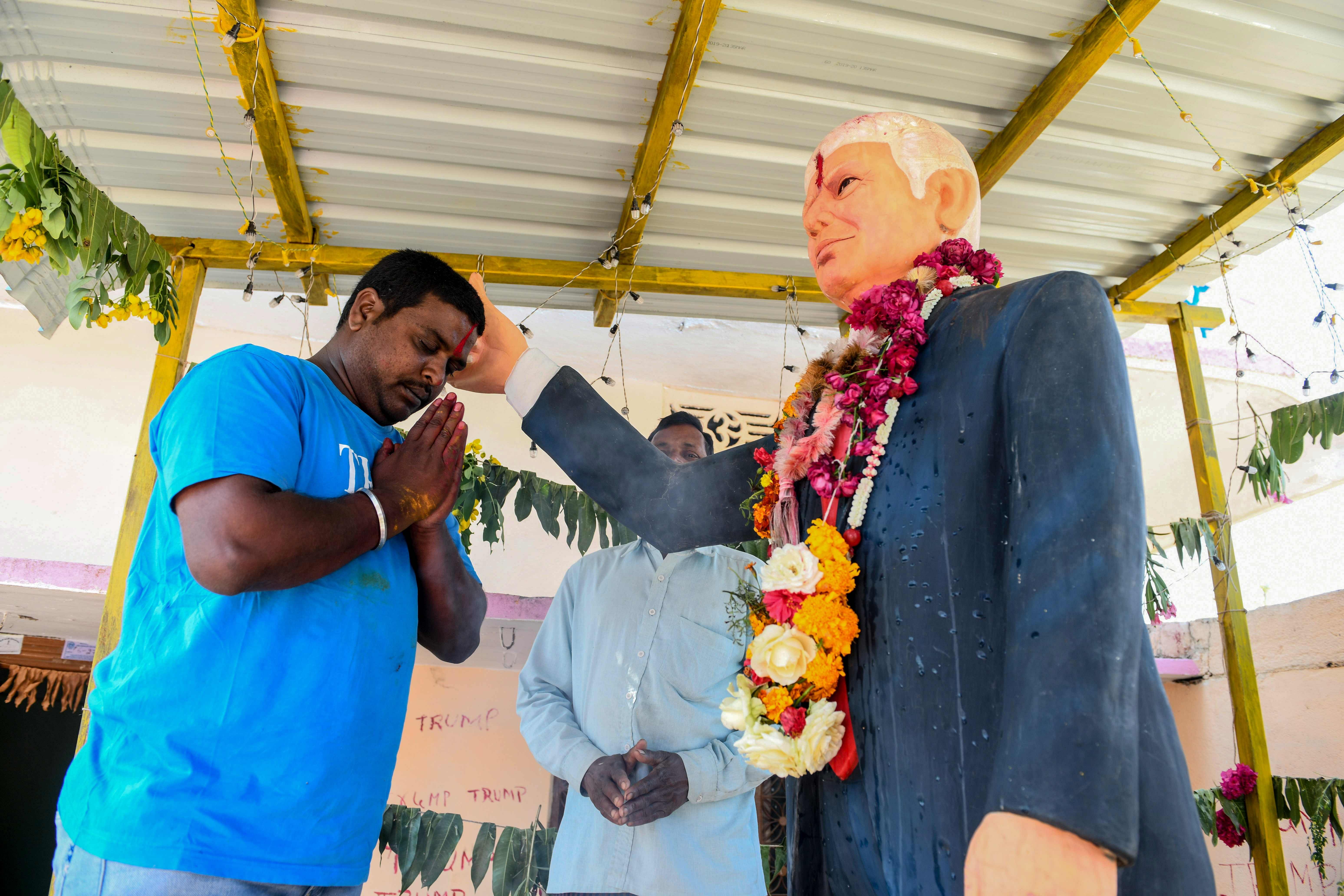 Farmer Bussa Krishna (L), 33, offers special prayers to the statue of US President Donald Trump, at his residence in Jangaon district in Telangana state. (AFP Photo)