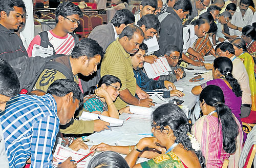Taxpayers seek help from officials at the special counters set up for submitting Income Tax returns at the Palace Grounds in Bangalore. As many as 65 counters will receive I-T returns till July 31. DH Photo